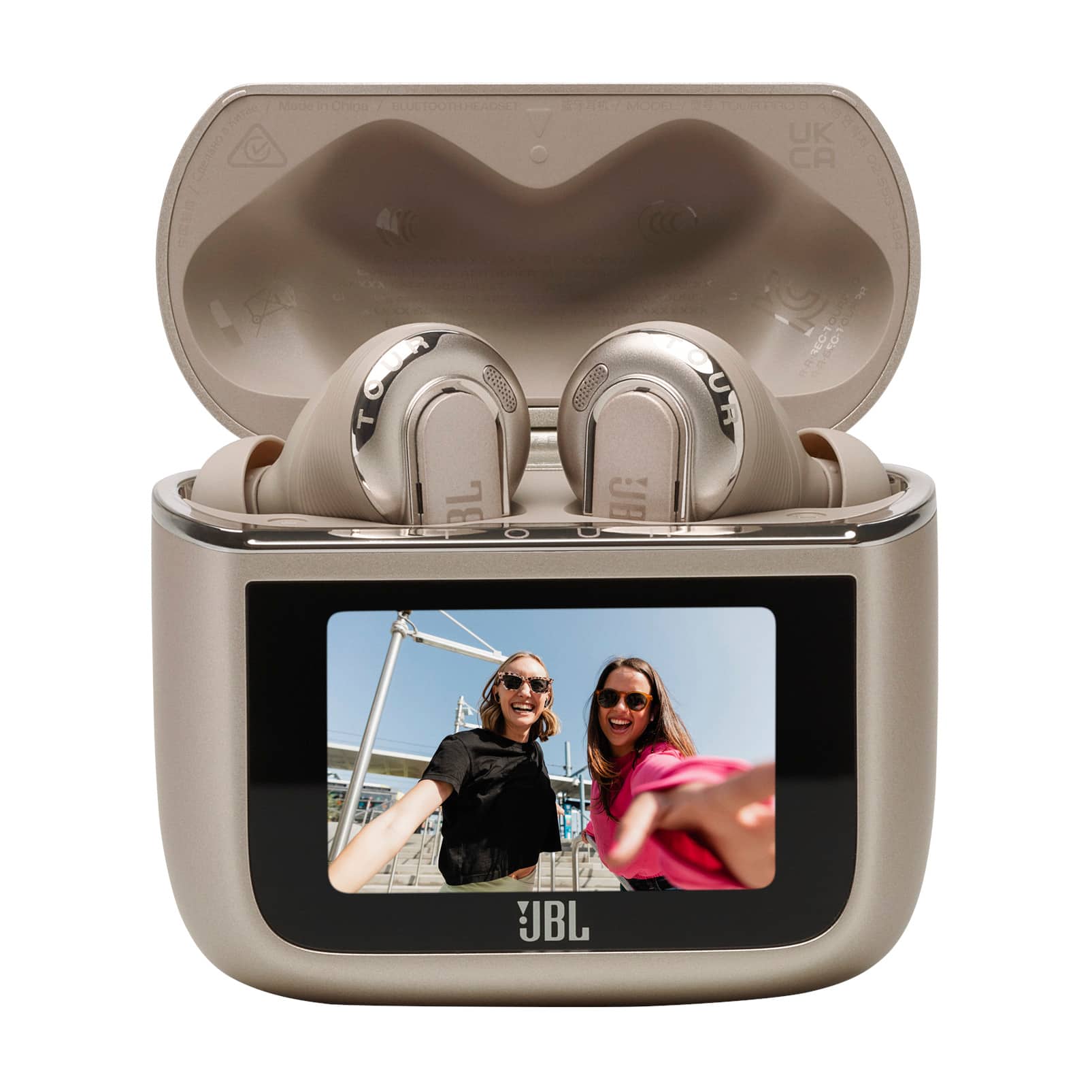 The image features two women standing next to each other, with one of them wearing sunglasses. They are both smiling, and the scene is captured on a small screen, possibly a cell phone or a camera. The women are positioned in front of a building, and there is a bench nearby. The image is likely taken in a public area or a park, as there is a bench available for people to sit and relax.