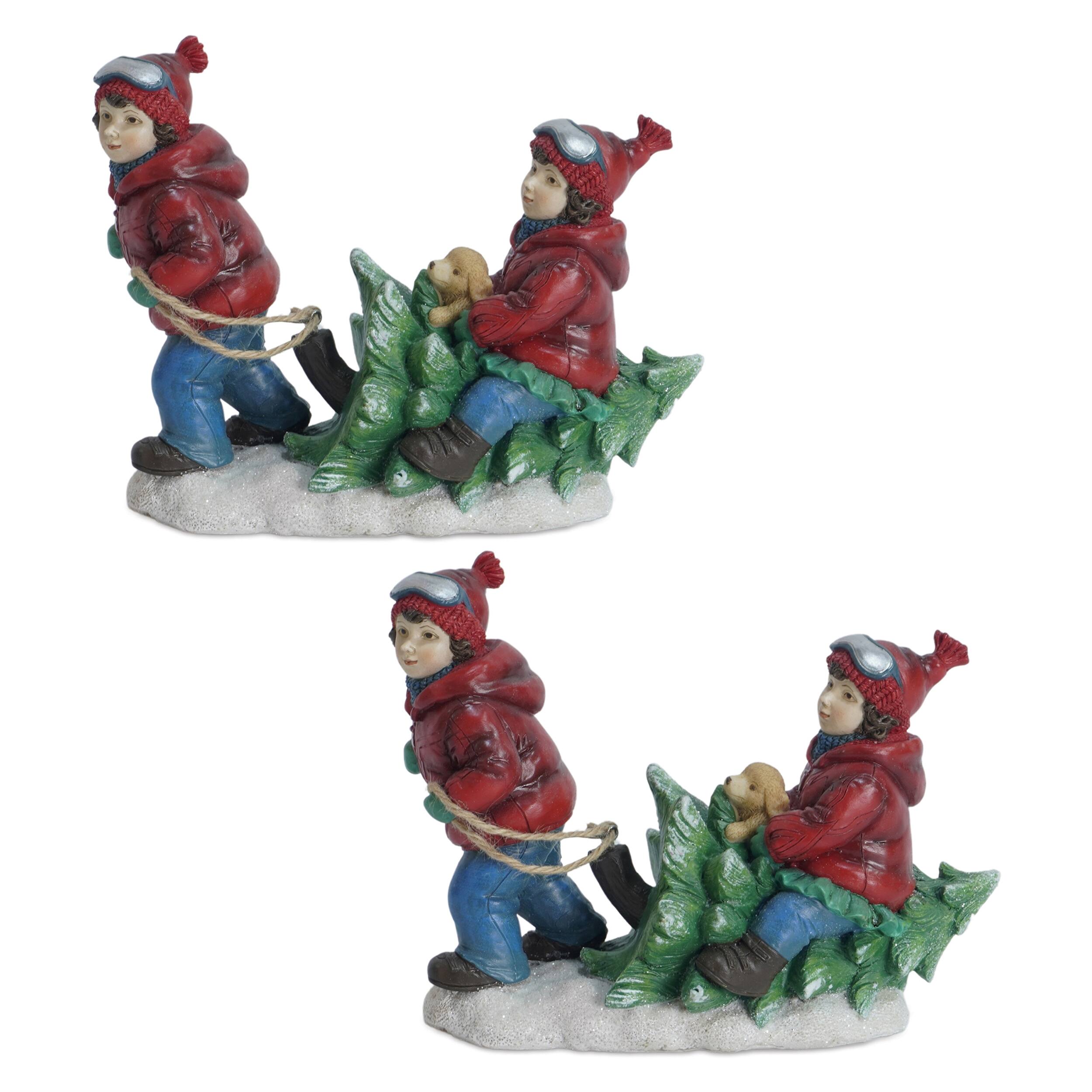 Angle. BreeBe - Holiday Children With Tree and Dog Figurine (Set of 2) - White, Blue, Red.
