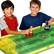 Two children are playing a game of soccer on a board game. They are using small figures to represent the players and are enjoying their time together.