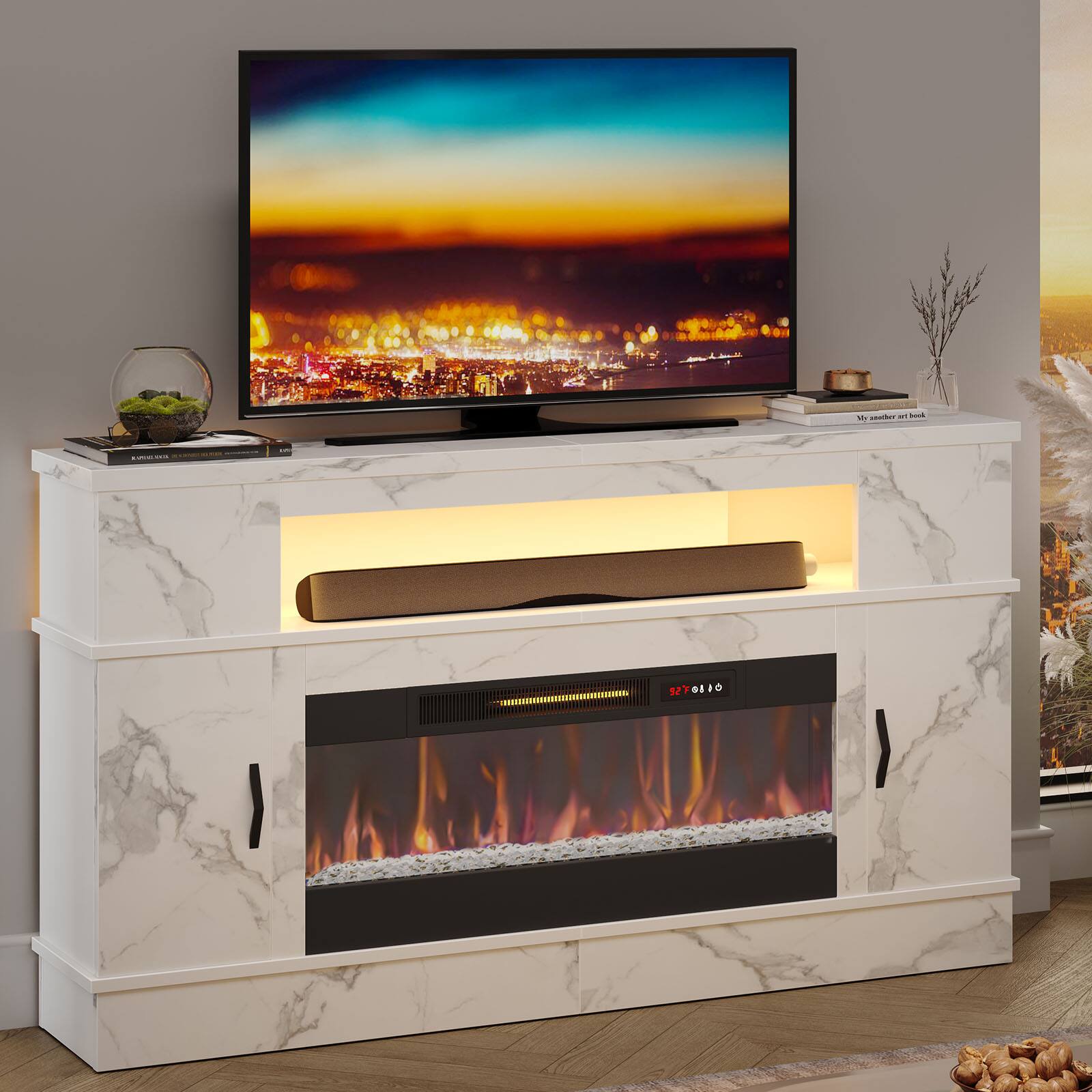 A flat screen TV is placed on a white marble stand. The TV is turned on and displaying a fireplace scene. The stand also has a fireplace built into it, adding a cozy ambiance to the room.
