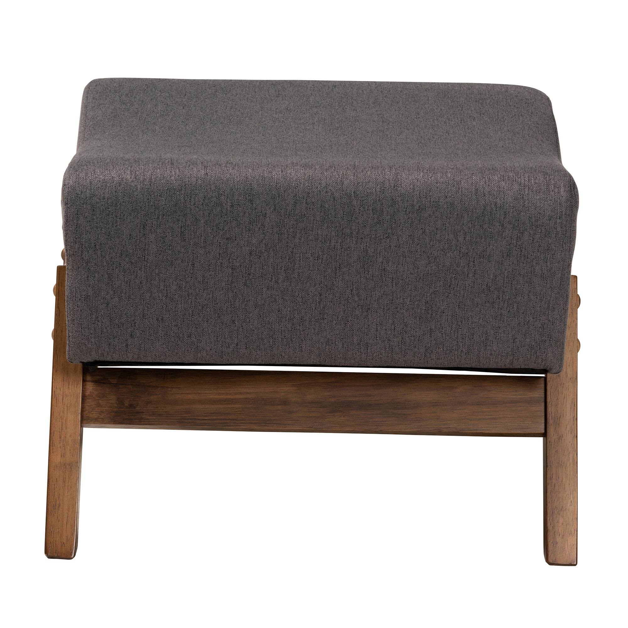 Angle. Baxton Studio - Hanson Mid-Century Modern Fabric and Walnut Brown Finished Wood Ottoman - Dark Grey/Walnut Brown.
