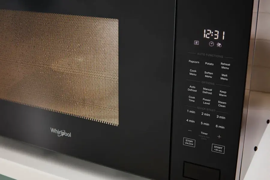 The image shows a Whirlpool microwave with the time 12:31 displayed on the screen. The microwave has various options such as Auto Functions, Popcorn, Potato Reheat, Menu, Cook Menu, Soften Menu, Melt Menu, OPTIONS, Auto Defrost, Manual Defrost, Keep Warm, Cook Time, Power Level, Steam Clean, and QUICK START. The microwave also has a timer feature that allows users to set the timer for 1 minute, 2 minutes, 3 minutes, 4 minutes, 5 minutes, 6 minutes, or even hold the timer button to add 30 seconds. Additionally, the microwave has a stop and unlock feature for added convenience.