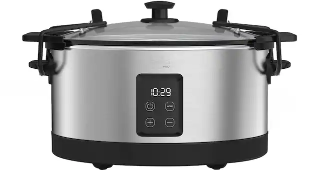 The image shows a silver Bella Pro 10:29 mode + I digital display on a stainless steel pot. The pot is sitting on a stove top, and the digital display is visible on the front of the pot.
