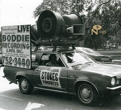 Sure, here is the corrected and grouped text from the image:
---
**BODDIE RECORDING & MFG. INC.**
CALL US DE CAN RECORD ANYTIME. RECORDS, ANY 2390 CASSETTES
752-3440
LOUIS STOKES CONGRESS
**LIVE**
**BODDIE RECORDING**
**& MFG. INC.**
**CALL US DE CAN RECORD ANYTIME. RECORDS, ANY 2390 CASSETTES**
**752-3440**
**LOUIS STOKES CONGRESS**
---
This text is from the signage on the car and the billboard.