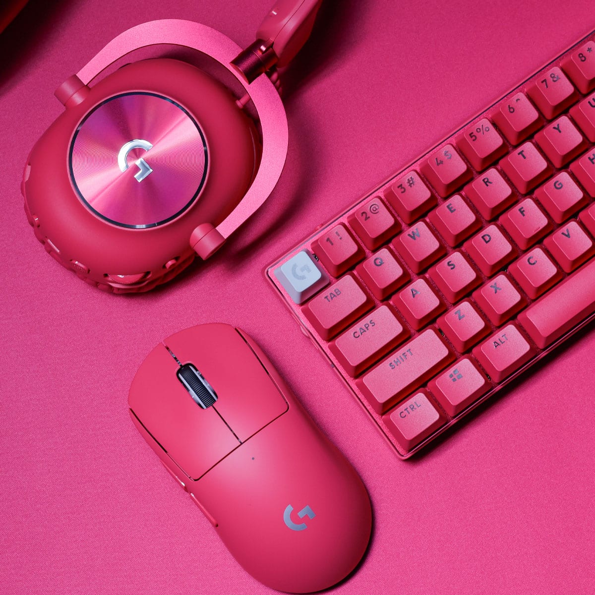 The image features a pink keyboard and mouse on a pink background. The keyboard is a compact design with red keys, and the mouse is also pink. The keyboard layout includes the numbers 1 through 9, as well as the letters A through Z. The arrangement of the keys is as follows:
1 2 3 4 5 6 7 8 9
A B C D E F G H I J K L M N O P Q R S T U V W X Y Z
The image also includes a pair of pink headphones, which are placed next to the keyboard and mouse.