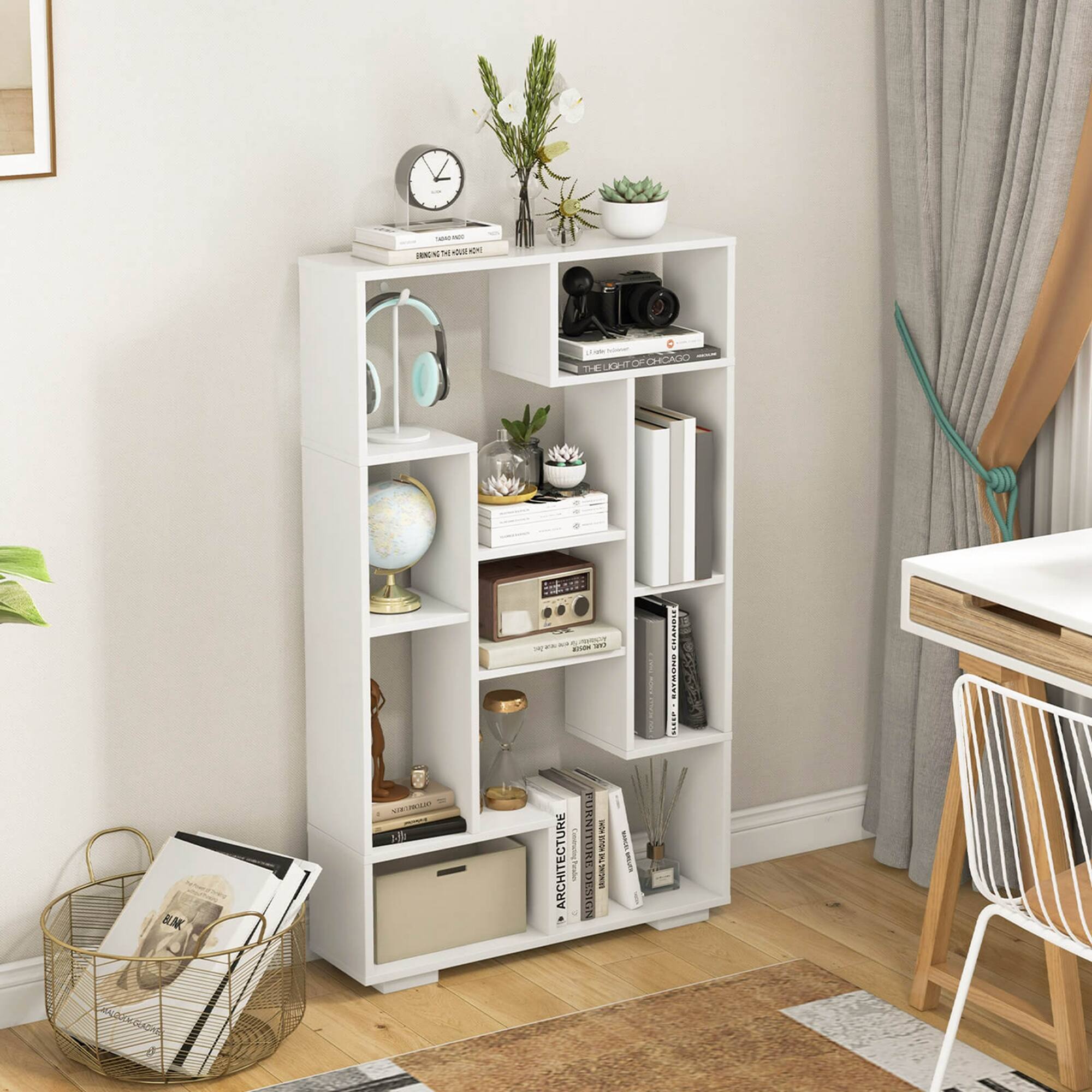 The image features a white shelf with various items on it, including a clock, a potted plant, and a vase. The shelf is placed on a wooden floor, and there is a chair nearby. The scene also includes a desk and a dining table, creating a cozy and functional living space.