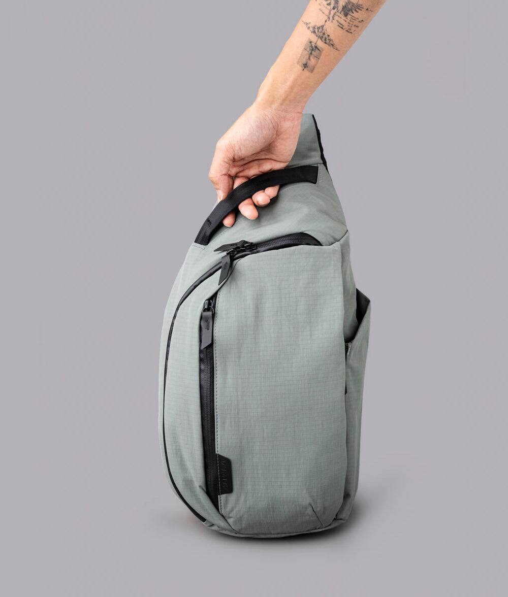 Alt View 1. ALPAKA - Crossbody Sling Bag 7.5L (Right Shoulder) for Men, Fits 11" Tablet, Phone Sleeve, Bottle Pocket, Luggage Pass-Through - Grey Axoflux 210D.