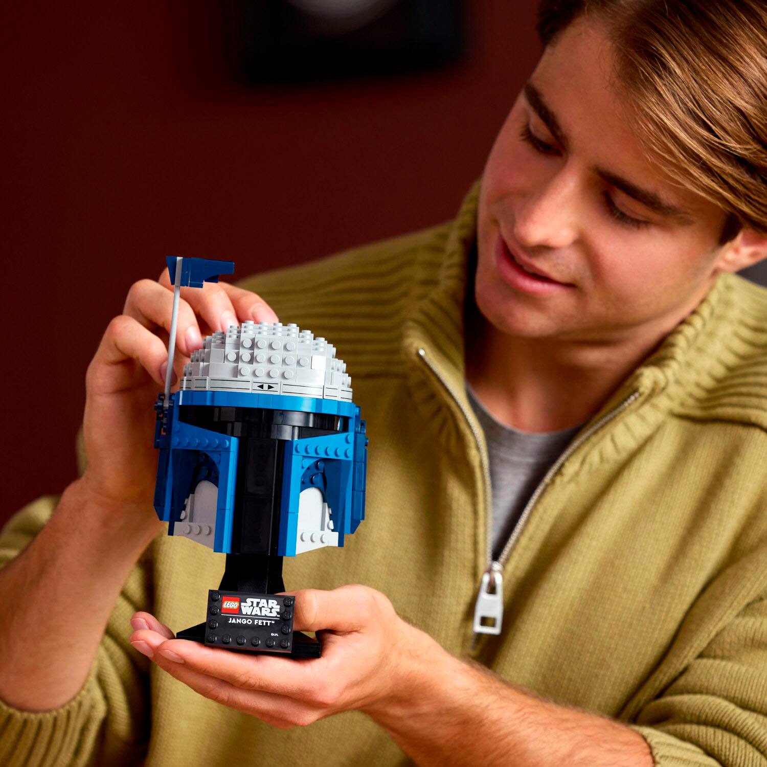 The man is holding a small Star Wars Jango Fett toy.