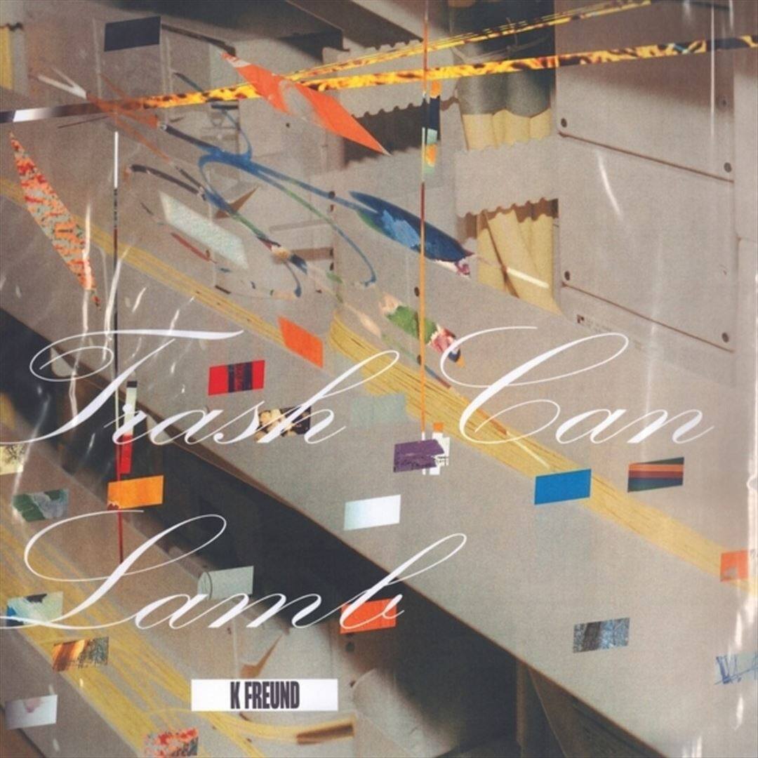 The image features a large text that reads "Trash Can Lamp." The text is white and is positioned in the center of the image. The rest of the image consists of various colors and shapes, creating a visually interesting and artistic composition.