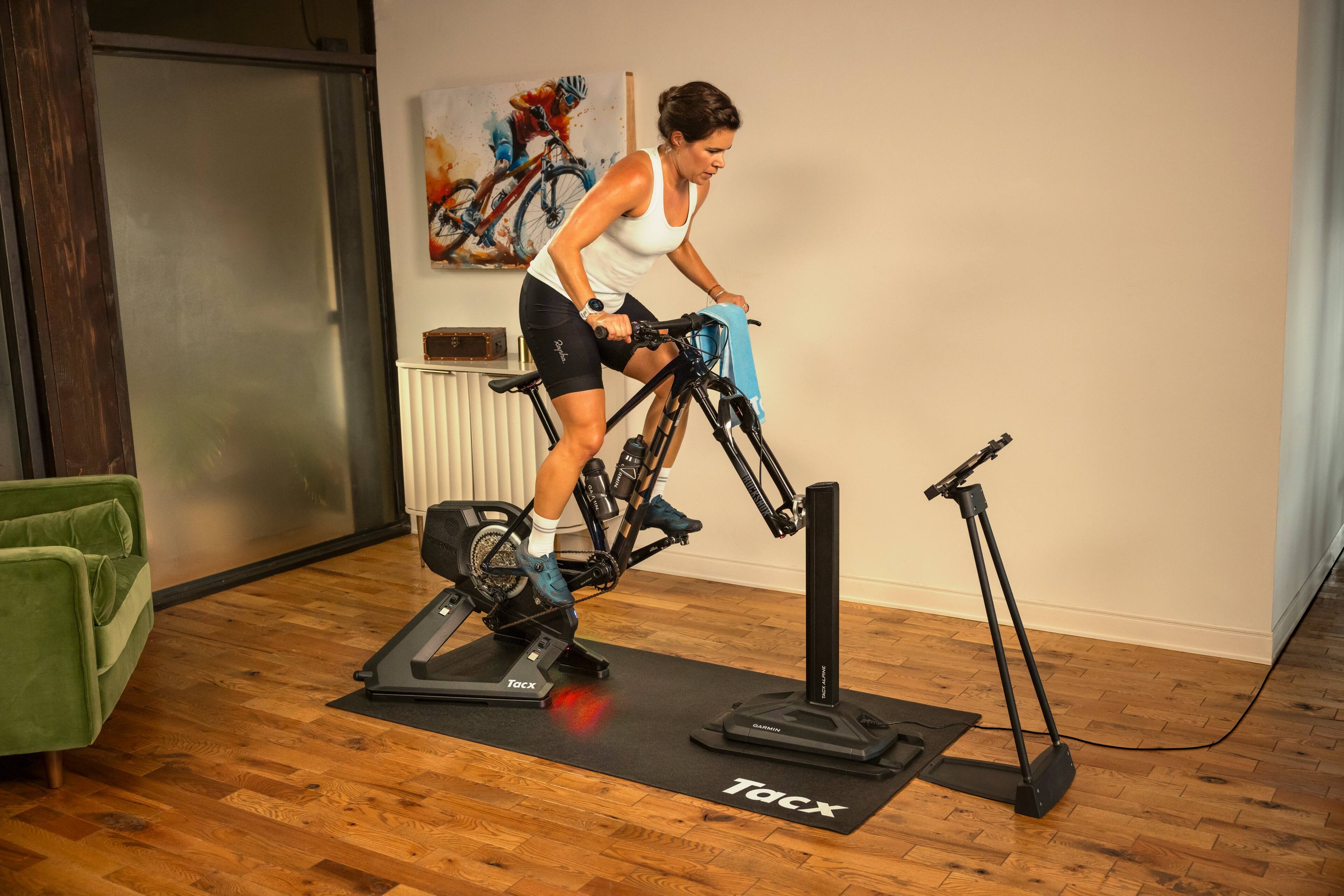 A woman is riding a Tacx bike in a room.