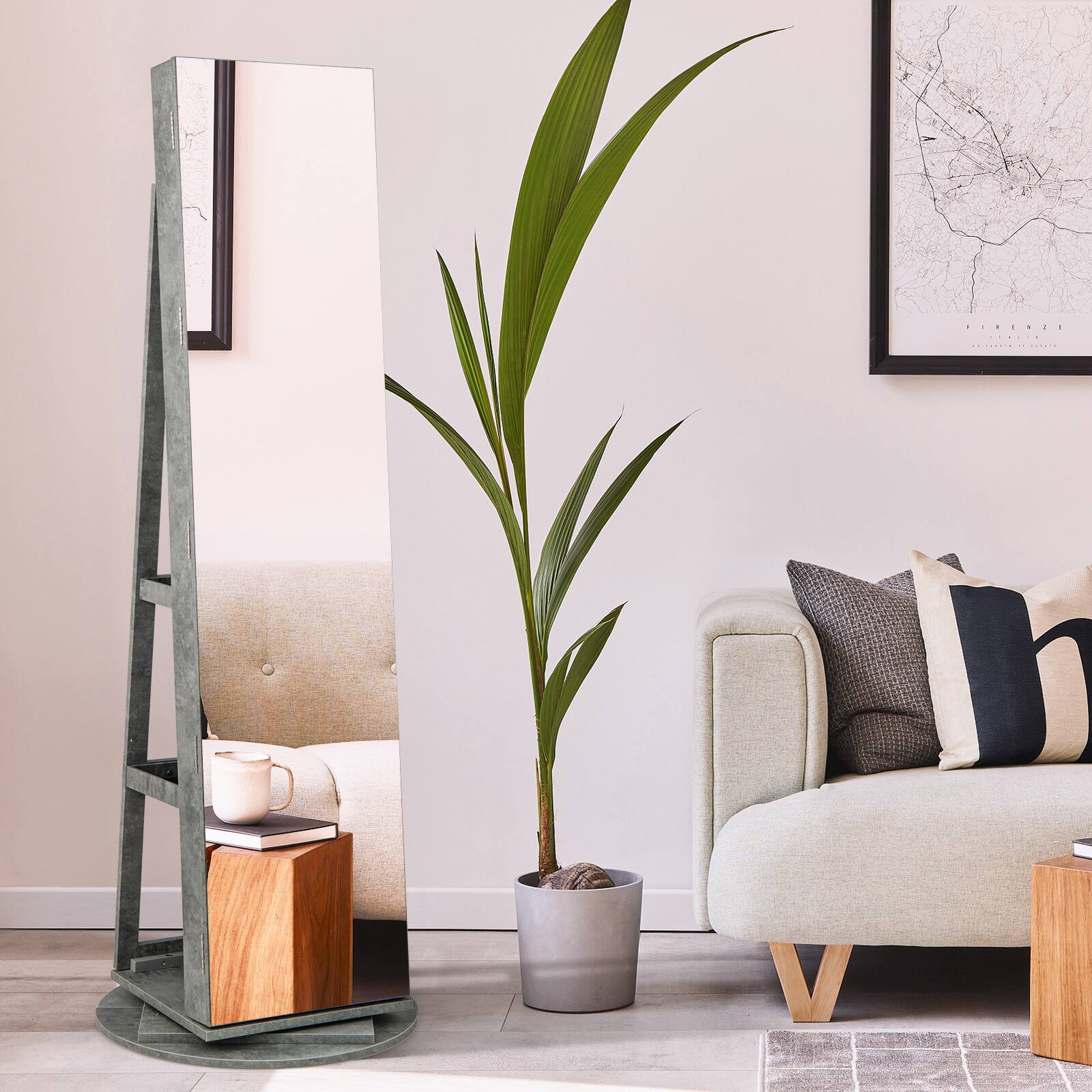 The image shows a modern living room setup with the following elements:

1. A tall, green plant in a gray pot.
2. A full-length mirror with a wooden base and a green frame.
3. A light-colored sofa with a textured fabric and wooden legs.
4. A framed map on the wall.
5. A wooden side table with a white mug and a book on top.
6. A gray and black patterned pillow on the sofa.
7. A light-colored rug on the floor.

The text on the map reads: "FRANCE" and "PARIS."