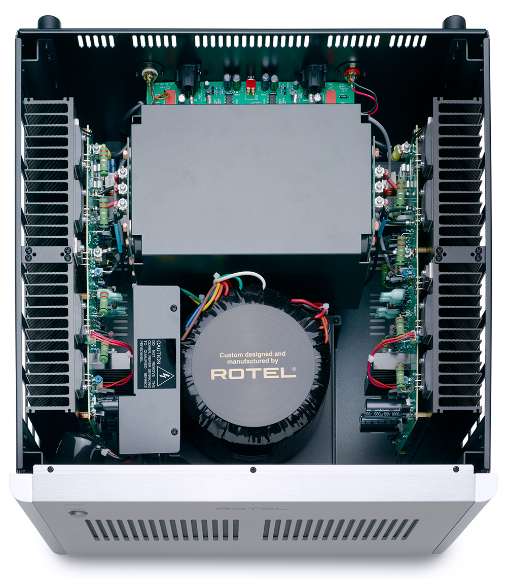 The image features a close-up view of a ROTEL electronic device, which is a custom-designed and manufactured piece of equipment. The device is housed in a white case, and it is filled with various electronic components, including wires and a transformer. The ROTEL device is likely used for a specific purpose, such as audio or video processing, and it is important to follow the manufacturer's guidelines and instructions for safe operation and use.
