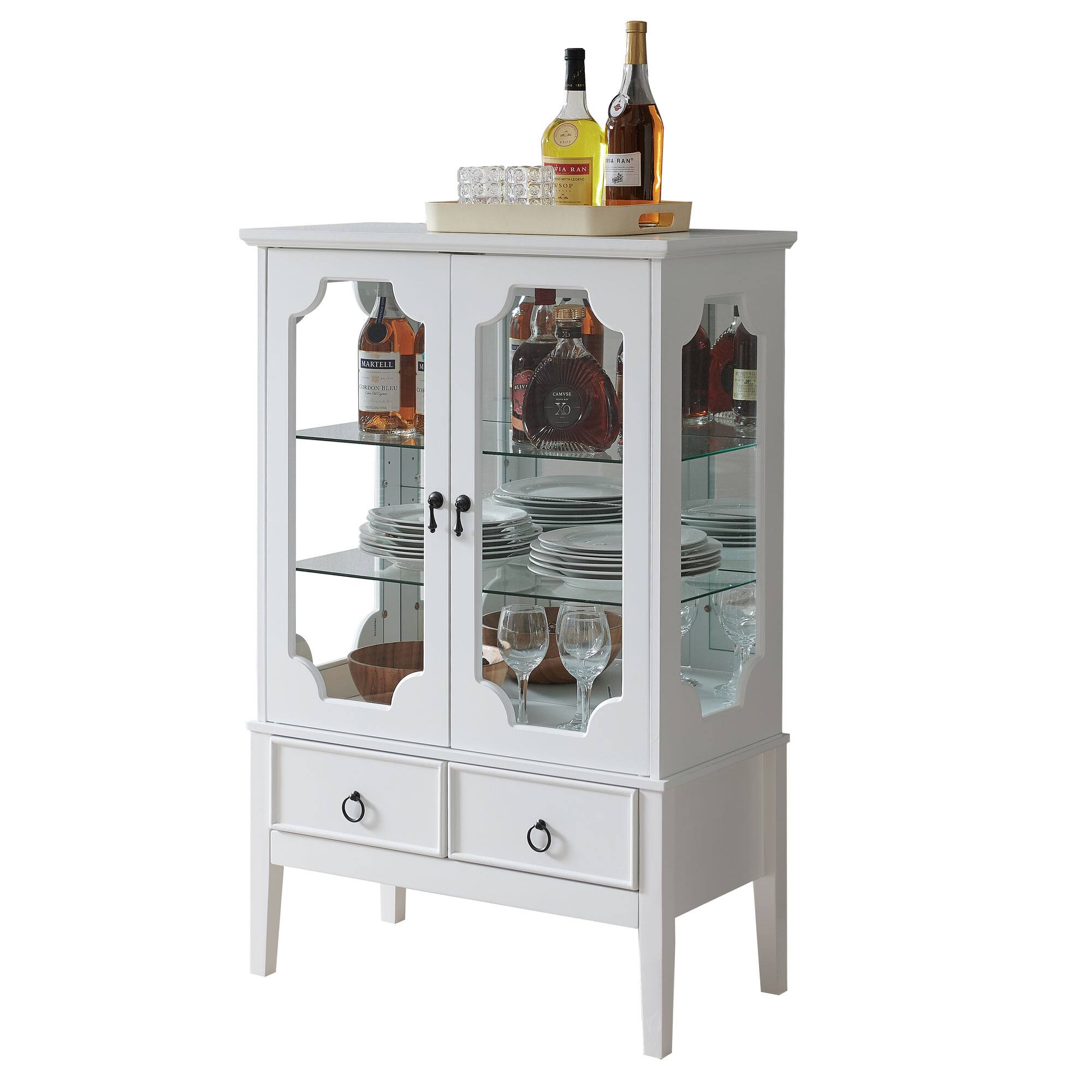 I see a white cabinet with glass doors, containing plates, glasses, and bottles. On top, there are two bottles and a tray with glasses.