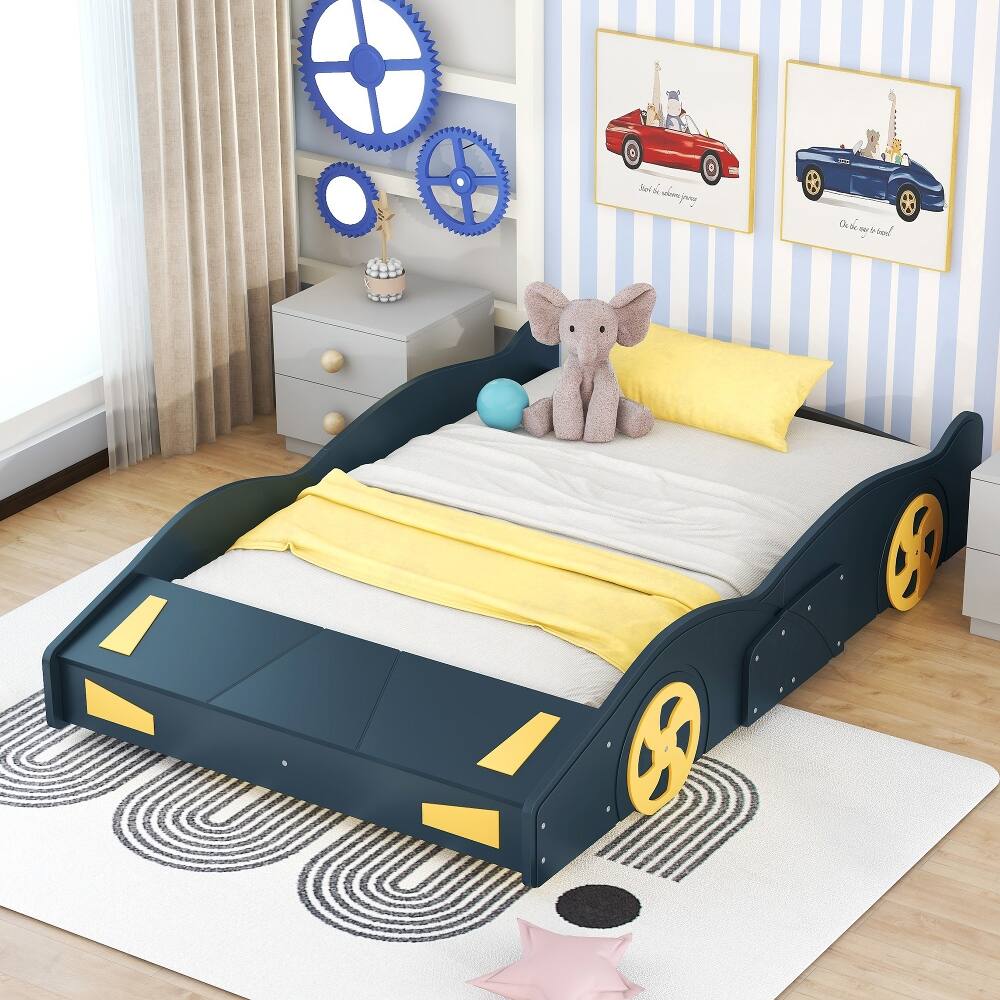 A dummy is lying on a bed with a yellow blanket and a stuffed elephant.
