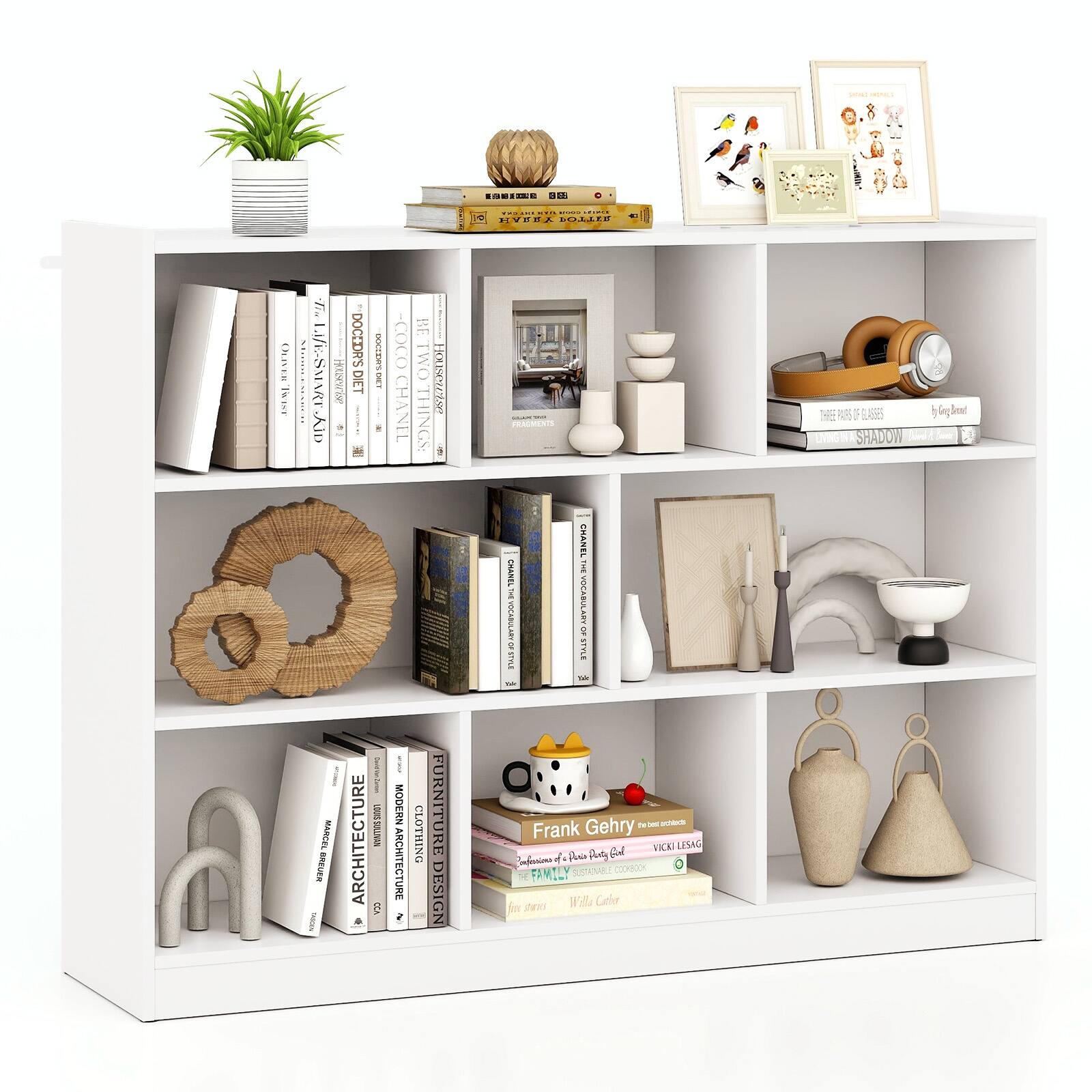 The image features a white bookshelf filled with various items. There are several books of different sizes and colors, as well as a vase, a clock, and a potted plant. The bookshelf also contains a collection of knick-knacks, which add to the overall decorative appeal of the space. The arrangement of these items creates an organized and visually appealing display, showcasing the diverse interests and personal touches of the owner.