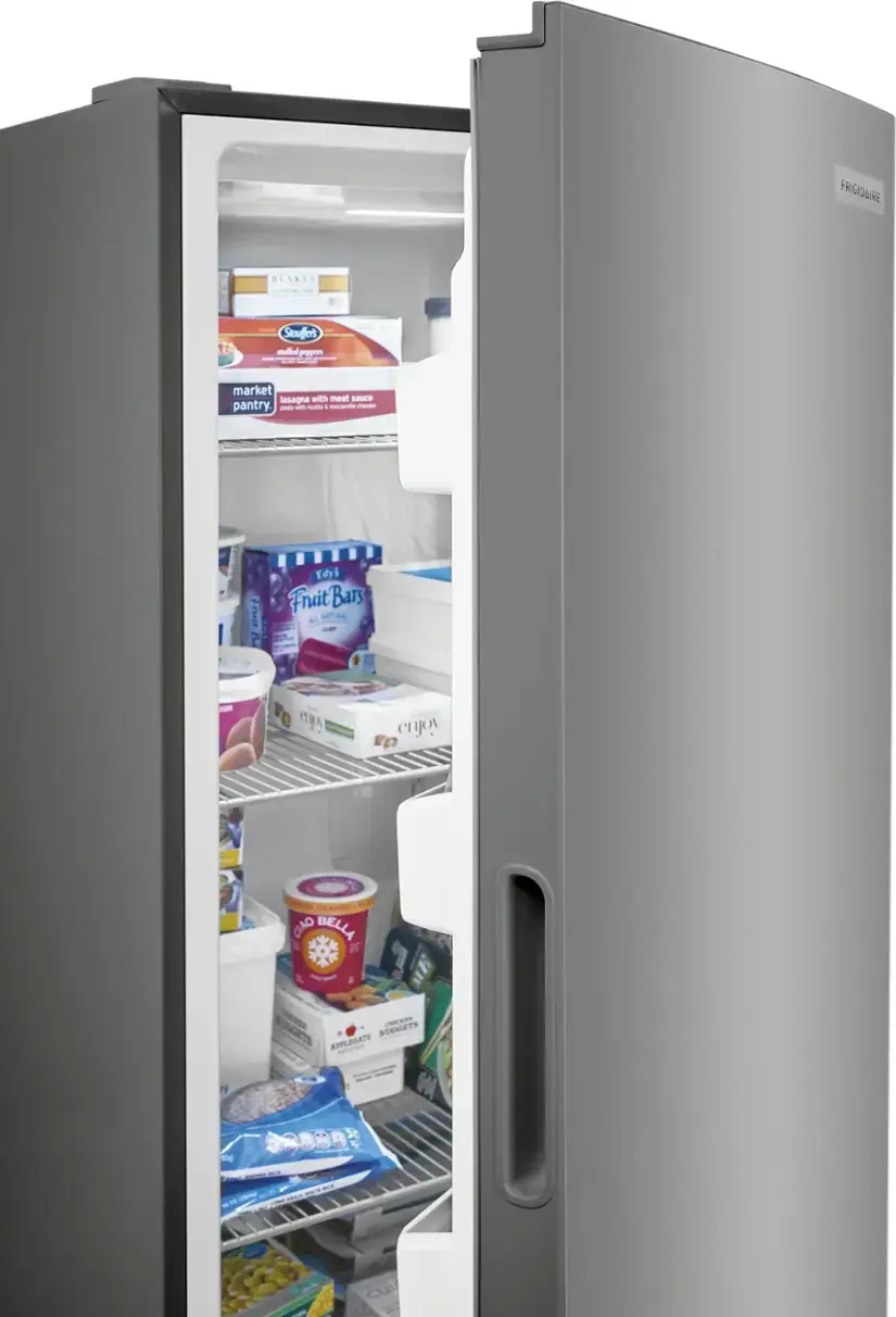 The image shows a refrigerator with its door open, revealing a variety of food items inside. There are several bottles, including a bottle of orange juice, and a container of yogurt. The refrigerator also contains a bowl and a cup. The refrigerator is filled with food, making it appear well-stocked and ready to use.