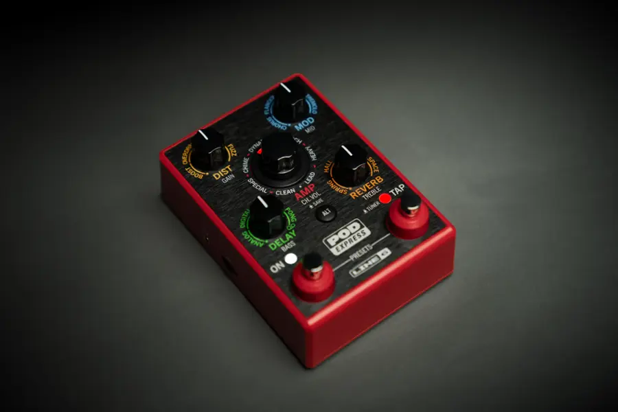 The image features a red electronic device with a variety of knobs and buttons on it. The knobs are labeled with different names, such as "Flange," "Tremolo," "Boost," "Overdrive," "Fuzz," "Dyna," "Heavy," "Lead," "Special," "Clean," "Amp," "Spring," "Reverb," "Treble," "Tap," "Vol," "Ch," "Save," and "Tuner." The device also has a digital display and an analog delay feature. The presence of these various knobs and buttons suggests that the device is a versatile and customizable electronic instrument, likely used for creating a wide range of sounds and effects.
