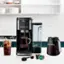 A NINJA coffee maker is sitting on a counter with a glass of iced tea and a glass of coffee.