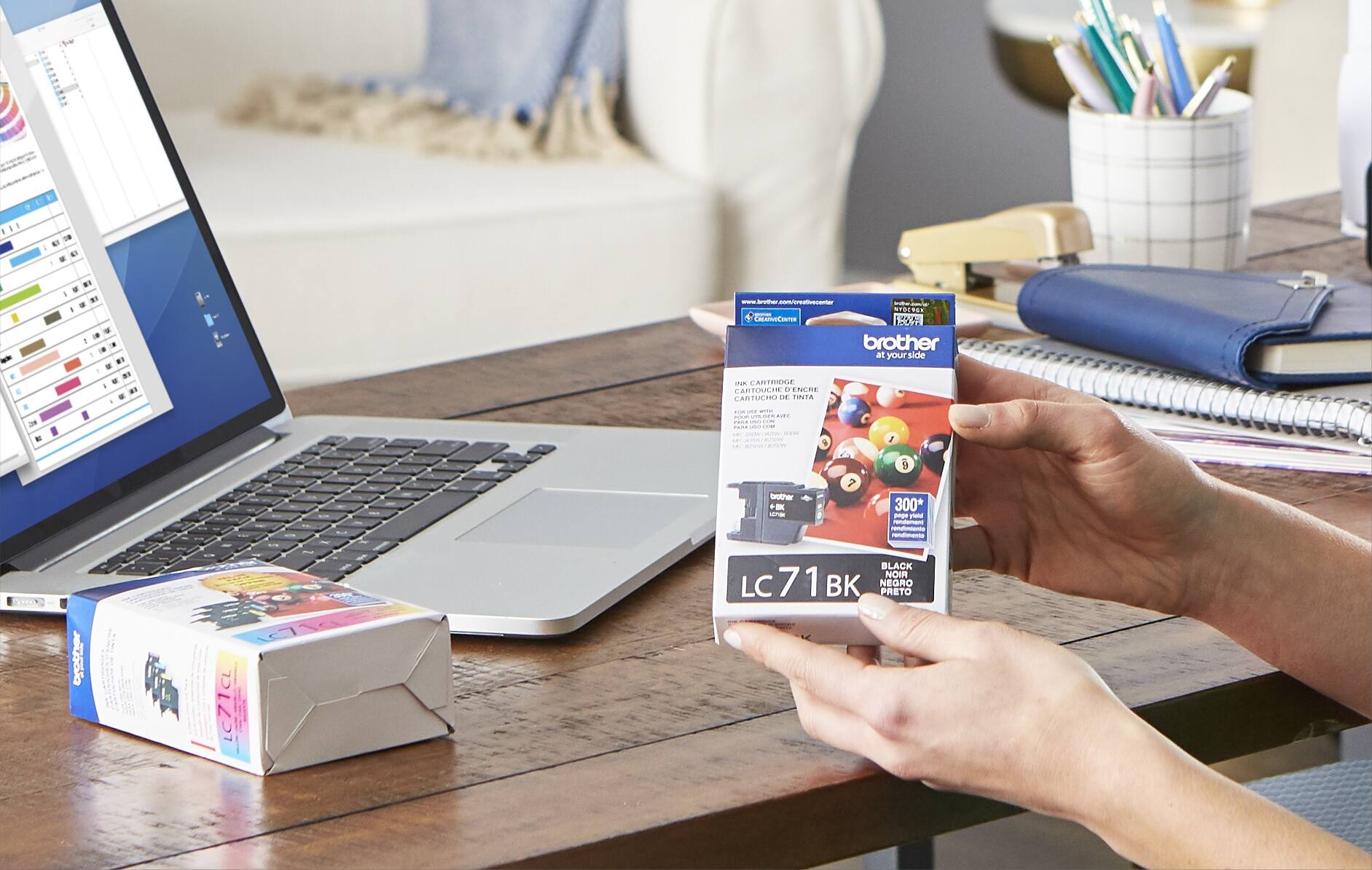 1. A box of Brother cartridges is sitting on the table next to the laptop.