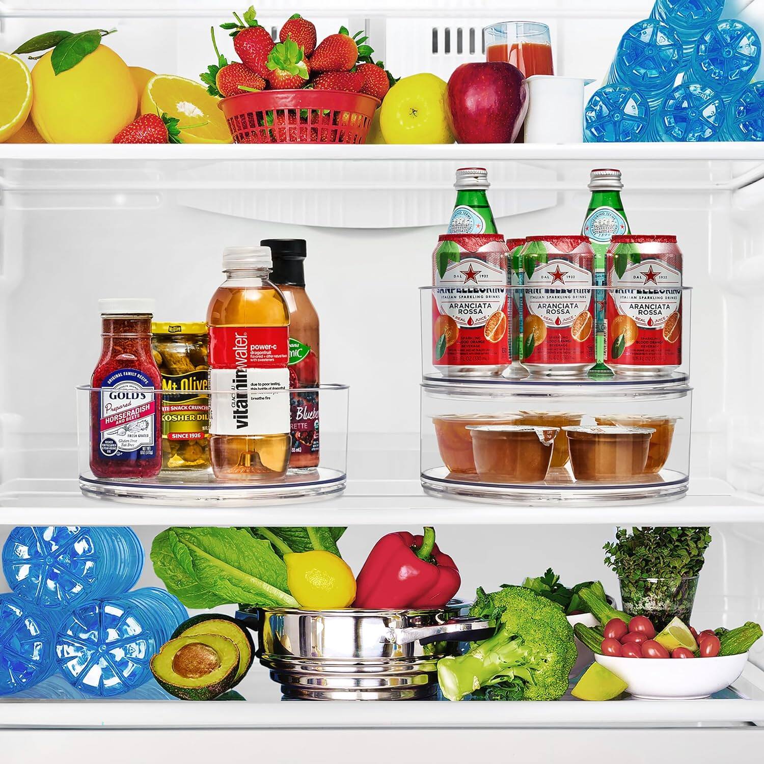 Sure, here is the corrected and grouped text from the image:

---

**Top Shelf:**
- Lemons
- Strawberries
- Apples
- Watermelon
- Blueberries

**Middle Shelf:**
- Gold's Mustard
- M&M's
- Vitamin E
- Blueberry
- Water Power
- Aranciata Rossa (3 bottles)

**Bottom Shelf:**
- Avocado
- Red Bell Pepper
- Broccoli
- Tomatoes
- Mint
- Lime
- Blue Ice Cubes

--- 

This text corresponds to the items visible in the refrigerator.