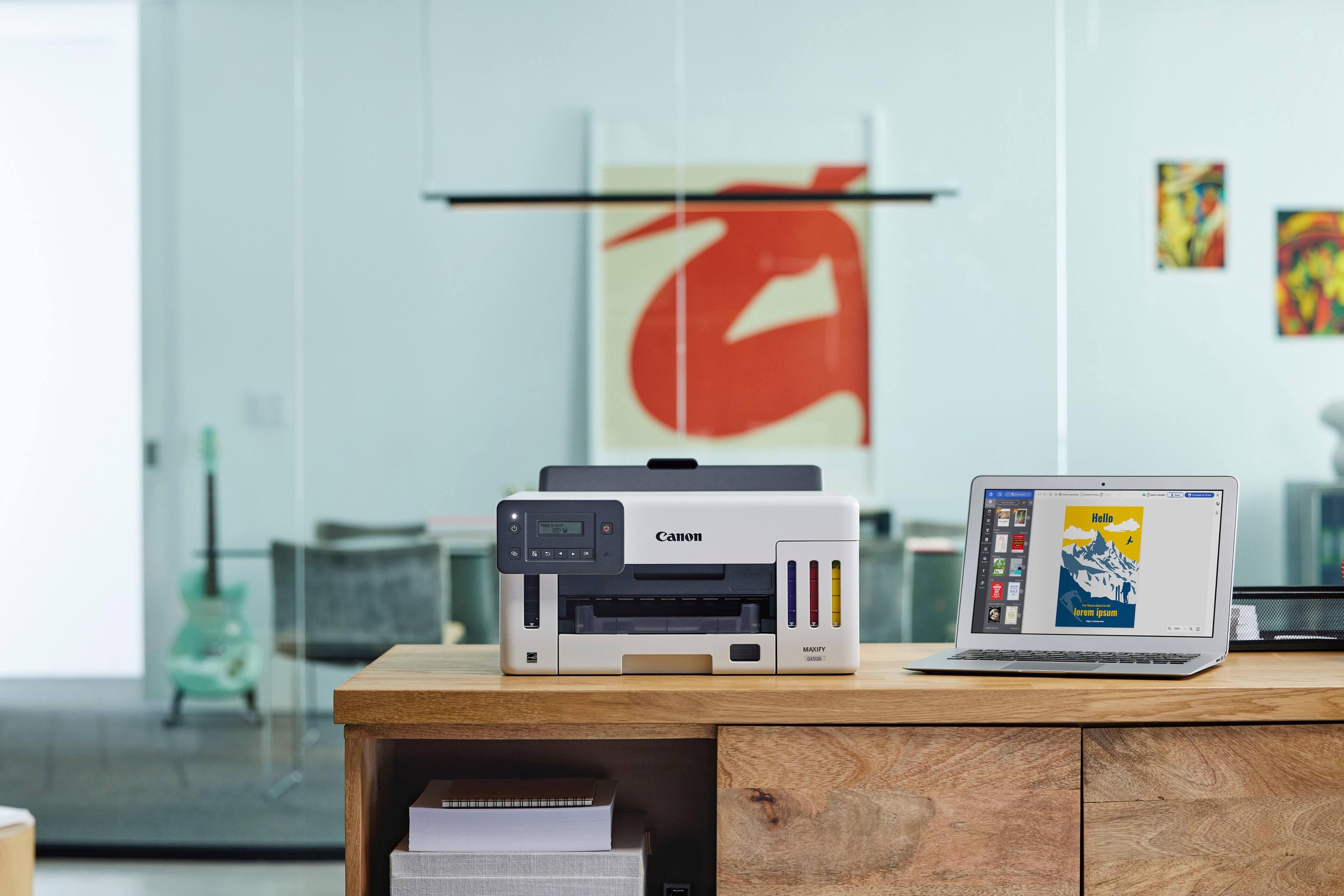 The image features a desk with various items on it. There is a laptop computer on the desk, along with a printer and a scanner. The printer and scanner are placed next to each other, and there are several books scattered around the desk. Additionally, there is a chair positioned near the desk, and a TV can be seen in the background. The overall scene suggests a workspace or home office setup.