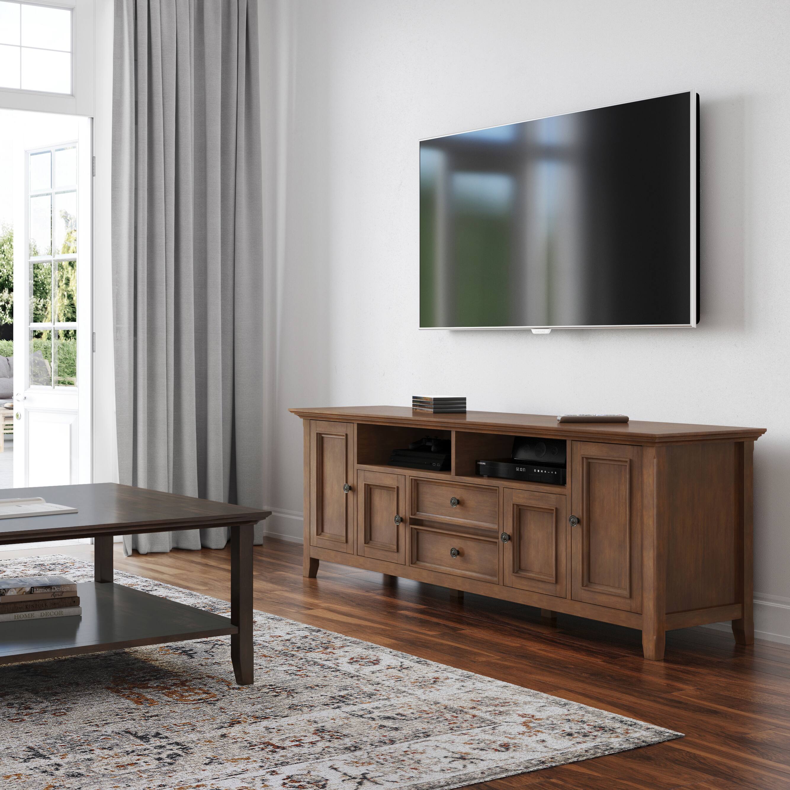 The text on the image reads: "A large flat screen TV sits on top of a wooden stand in a living room."