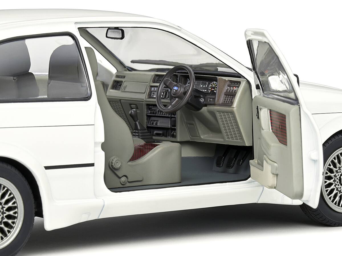 Left. Solido - 1987 Ford Sierra RS500 RHD (Right Hand Drive) White with Black Stripes 1/18 Diecast Model Car by Solido - White With Black.