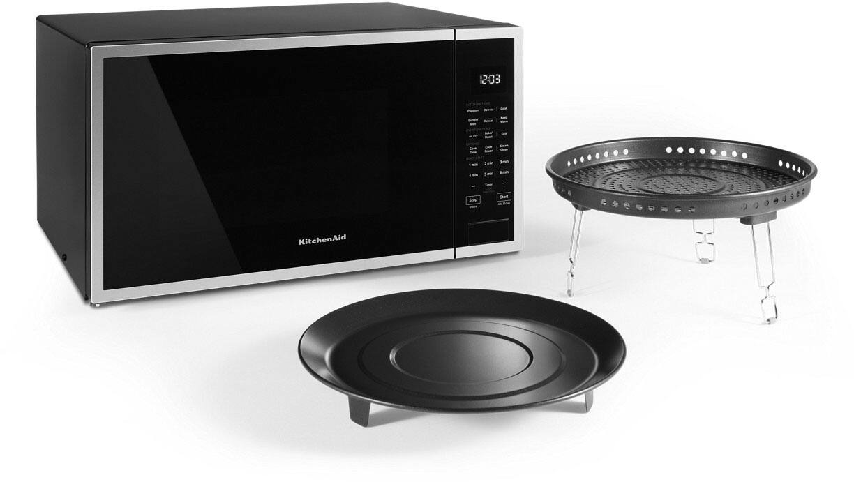 The text on the image reads "12:03 + THP Sutt KitchenAid." This text is likely a combination of a time stamp and a product name. The time stamp "12:03" indicates that the image was taken at 12:03. The product name "KitchenAid" suggests that the image features a kitchen appliance, possibly a microwave or a cooking appliance. The text "THP Sutt" could be a reference to the brand or model of the appliance, or it could be an abbreviation of the product name.