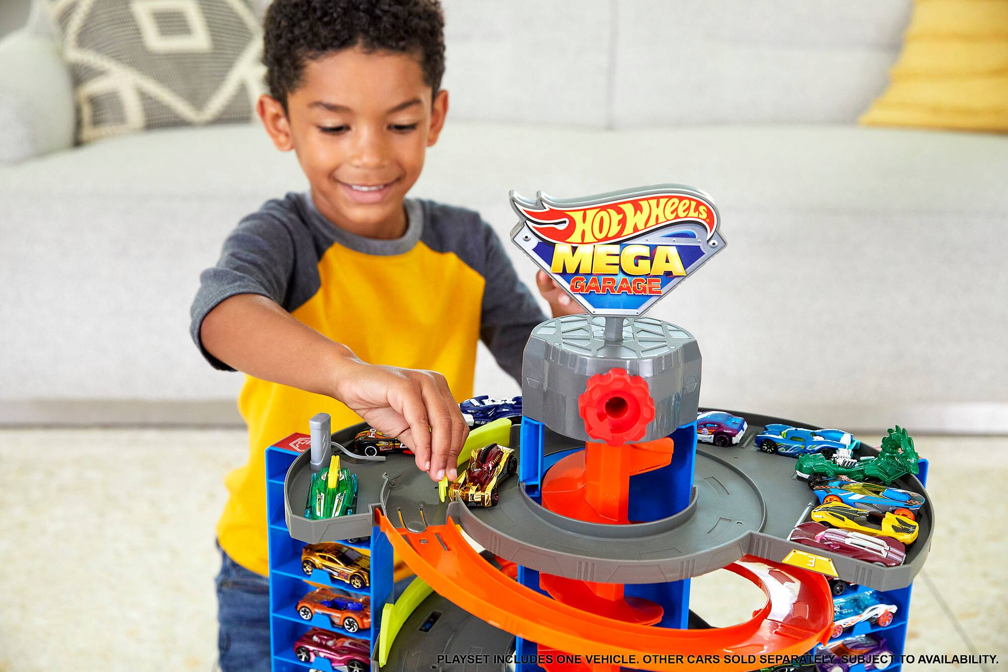 The text on the image reads: "HOW HOT WHEELS MEGA GARAGE 3 PLAYSET INCLUDES ONE VEHICLE. OTHER CARS SOLD SEPARATELY SUBJECT TO AVAILABILITY."