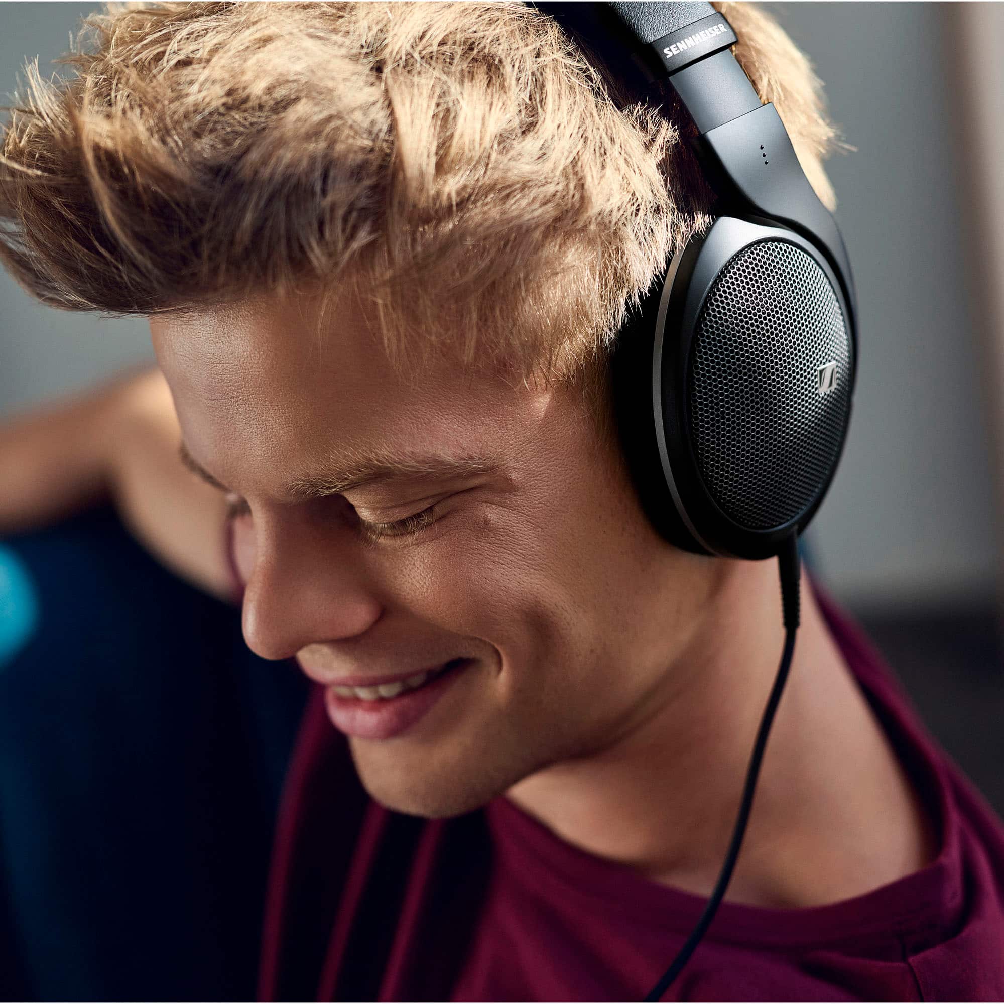Sennheiser headphones are being worn by a smiling man.