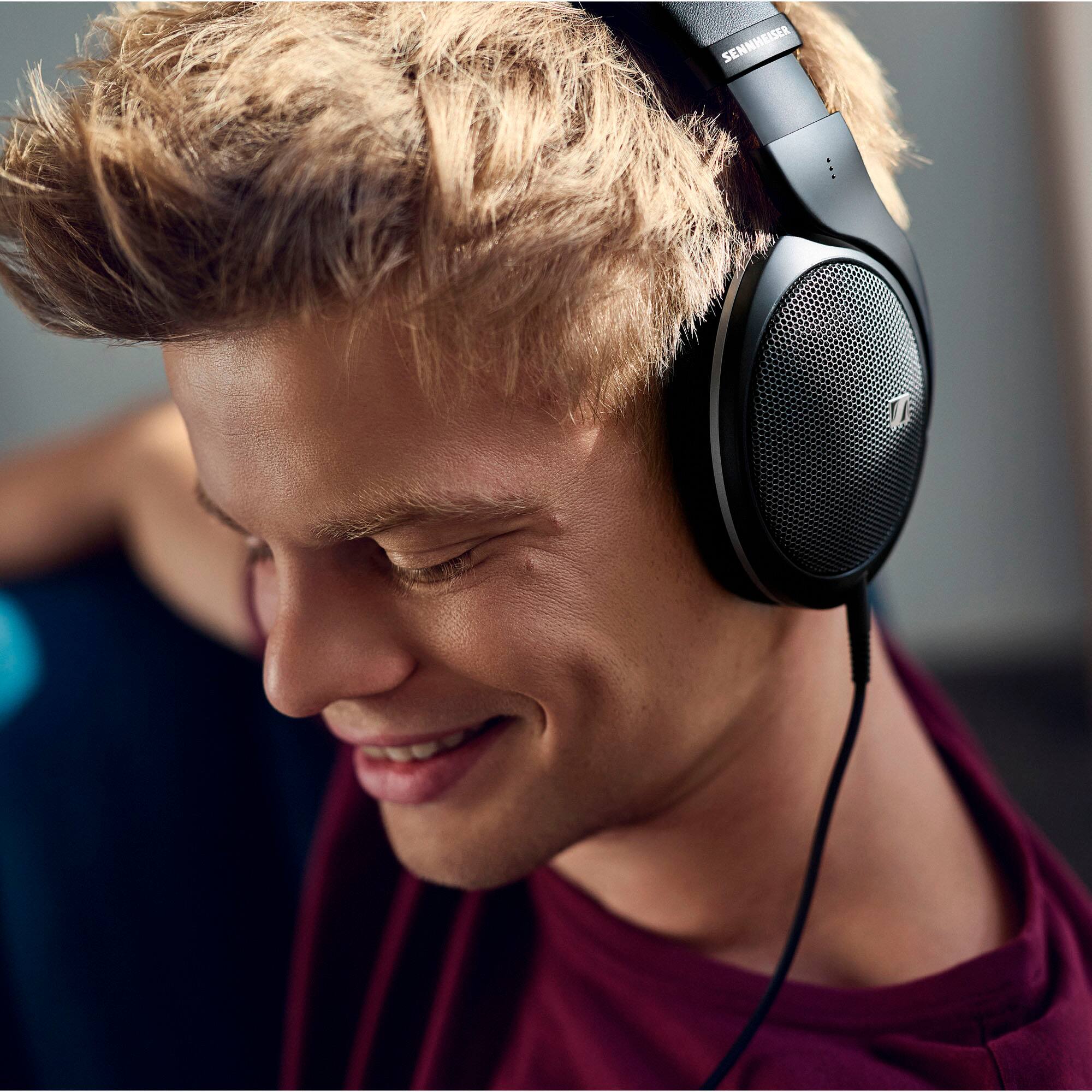 Sennheiser headphones are being worn by a smiling man.