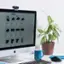 The image shows a computer monitor sitting on a desk. The monitor displays a web page with a list of items and their prices. The list includes items such as headphones, a mouse, and a cup. The prices range from $79.00 to $39.00. The computer setup also includes a keyboard and a potted plant nearby.