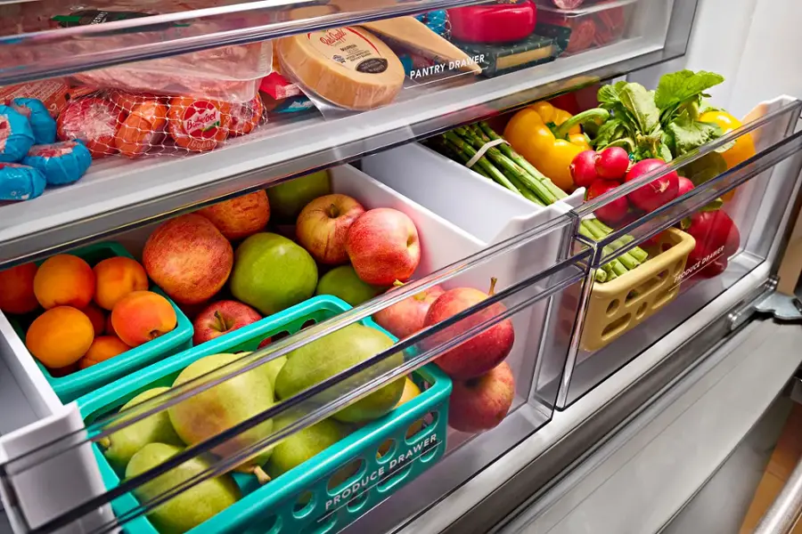 The image shows a refrigerator with a produce drawer and a pantry drawer. The produce drawer is filled with various fruits such as apples, oranges, and broccoli. The pantry drawer contains items like cheese and vegetables. The refrigerator is stocked with a variety of food items, making it a convenient and organized storage solution for a household.