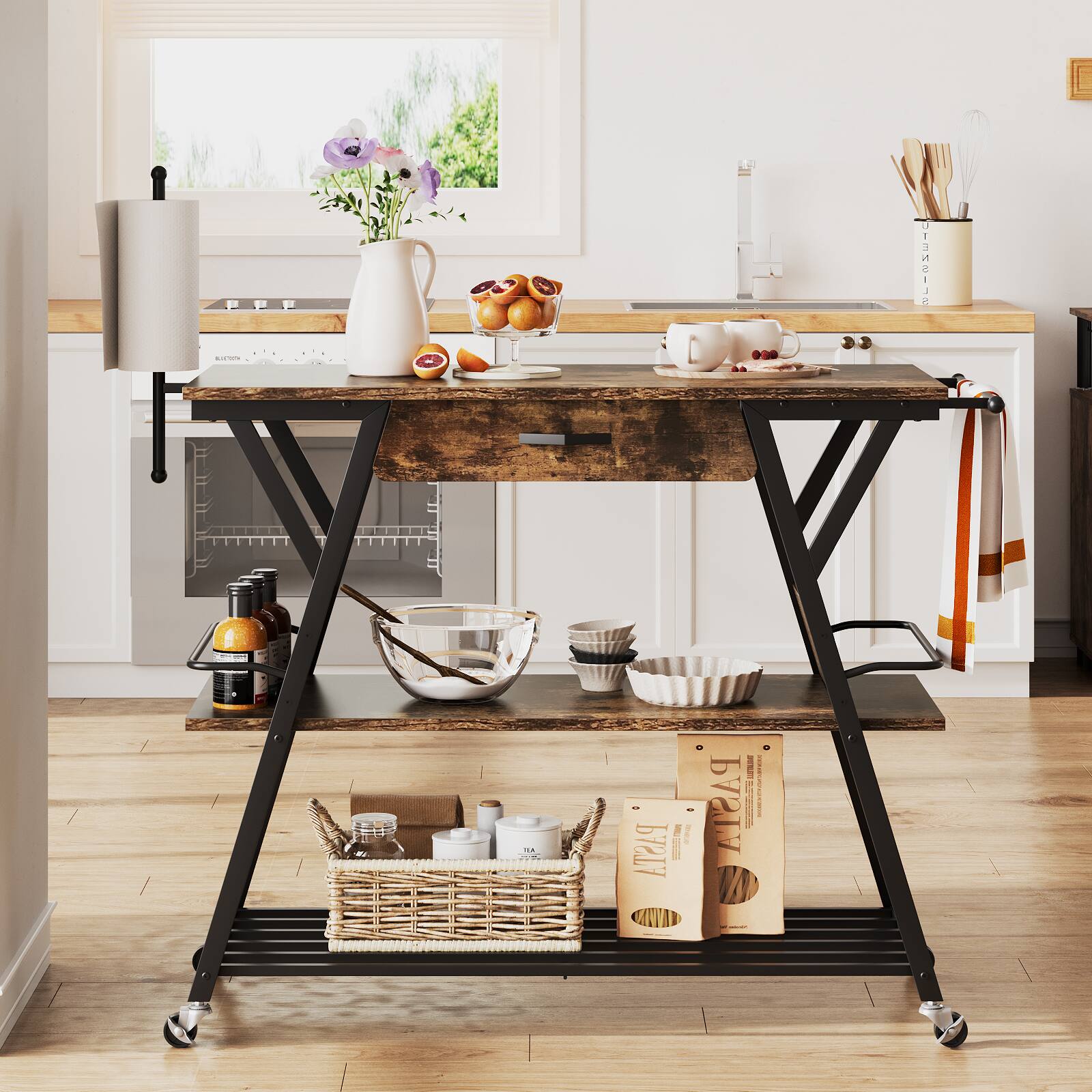 The image features a kitchen with a wooden table, a counter, and a small island. On the table, there are various items such as a vase with flowers, a bowl, and a cup. Additionally, there are several bottles and bowls placed around the kitchen. The counter has a cutting board and a bowl on it. The small island has a bowl and a cup on it. The kitchen also has a sink and an oven.