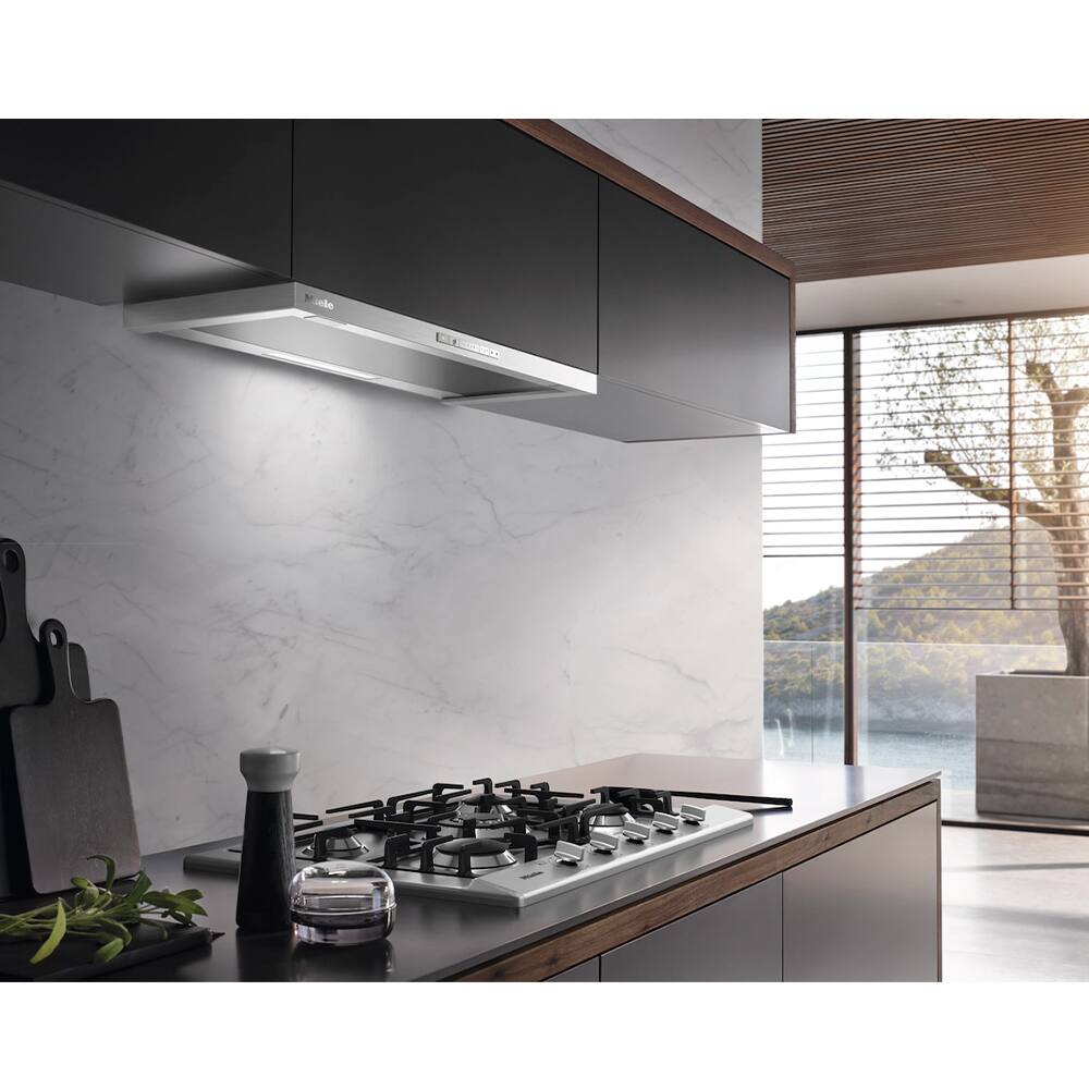 "The kitchen has a stove top oven with a black and white color scheme. The stove is located next to a window, allowing for natural light to enter the room. The kitchen also features a sink and a spice rack. The overall design of the kitchen is modern and sleek, with a black and white color scheme that gives it a clean and elegant appearance."