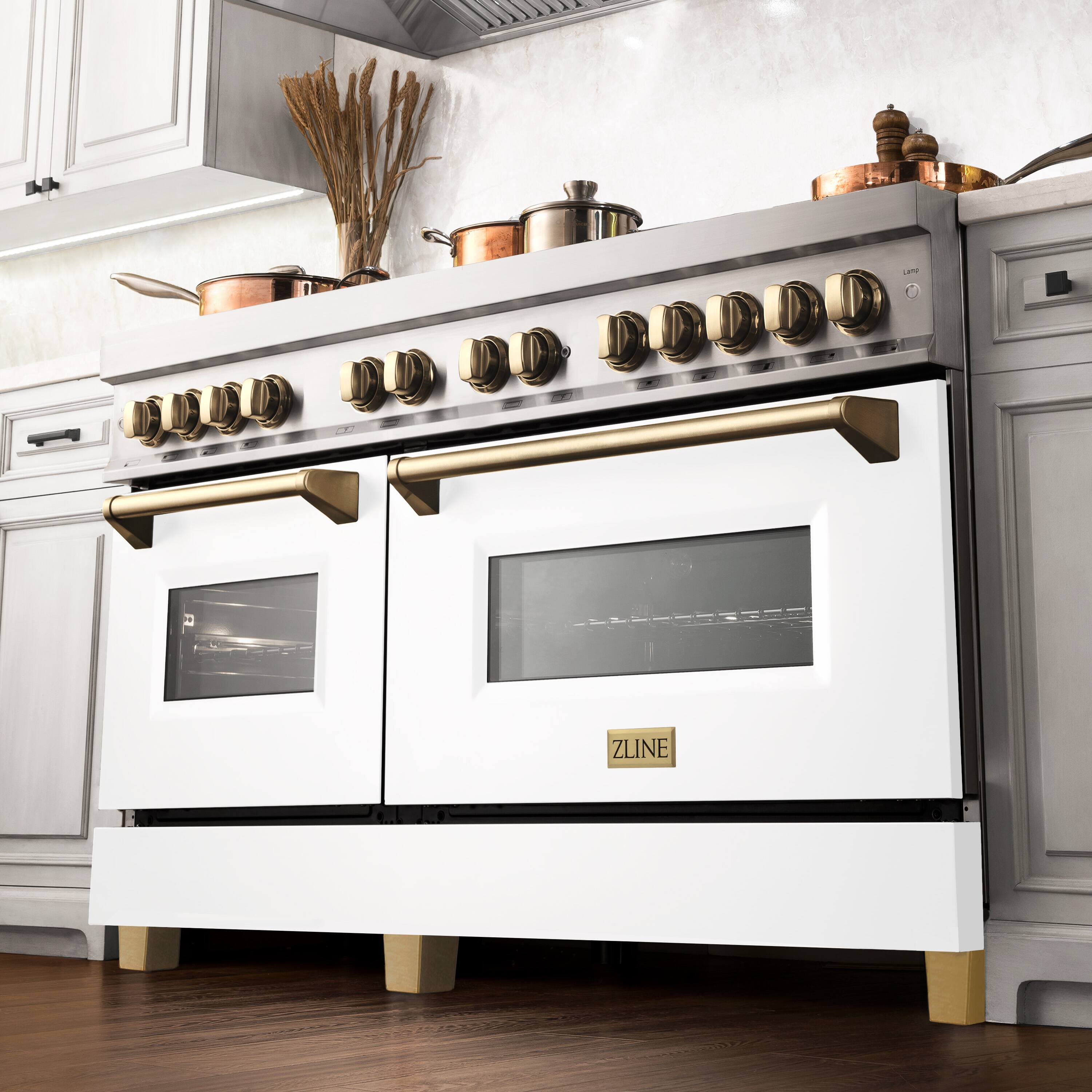 The image features a white and gold ZLINE oven with two ovens. The oven is positioned on a wooden floor, and there are several pots and pans on the stove. The stove is equipped with a range of knobs, and there is a vase placed on the countertop. The overall scene showcases a well-equipped kitchen with a modern and stylish design.