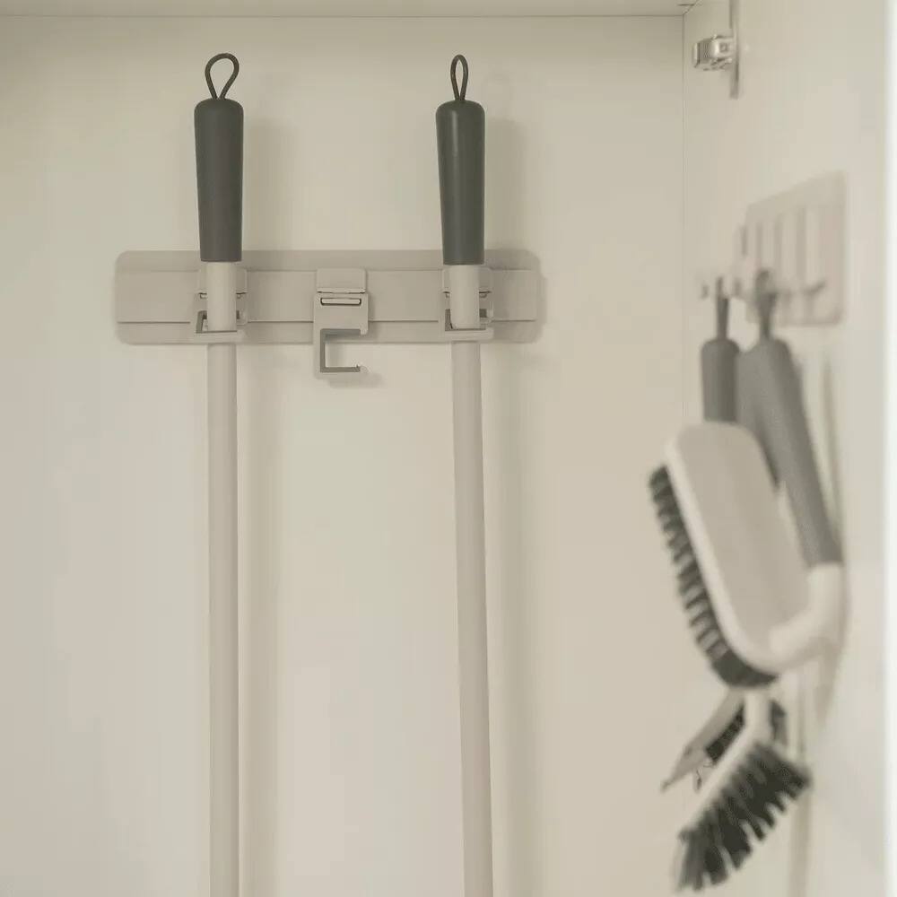 Left. OU - Wall Mounted Broom & Mop Holder, Self‑Adhesive Anti‑Slip Silicone Grip Hooks for Laundry & Kitchen Organization - Beige.