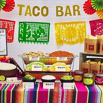TACO BAR

- Chopped Tomatoes
- Chopped Onions
- Chopped Jalapeños
- Shredded Cheese
- Sour Cream
- Guacamole
- Salsa
- Refried Beans
- Shredded Chicken
- Shredded Beef
- Shredded Pork
- Corn Tortillas
- Flour Tortillas

ES A
[Logo with text]