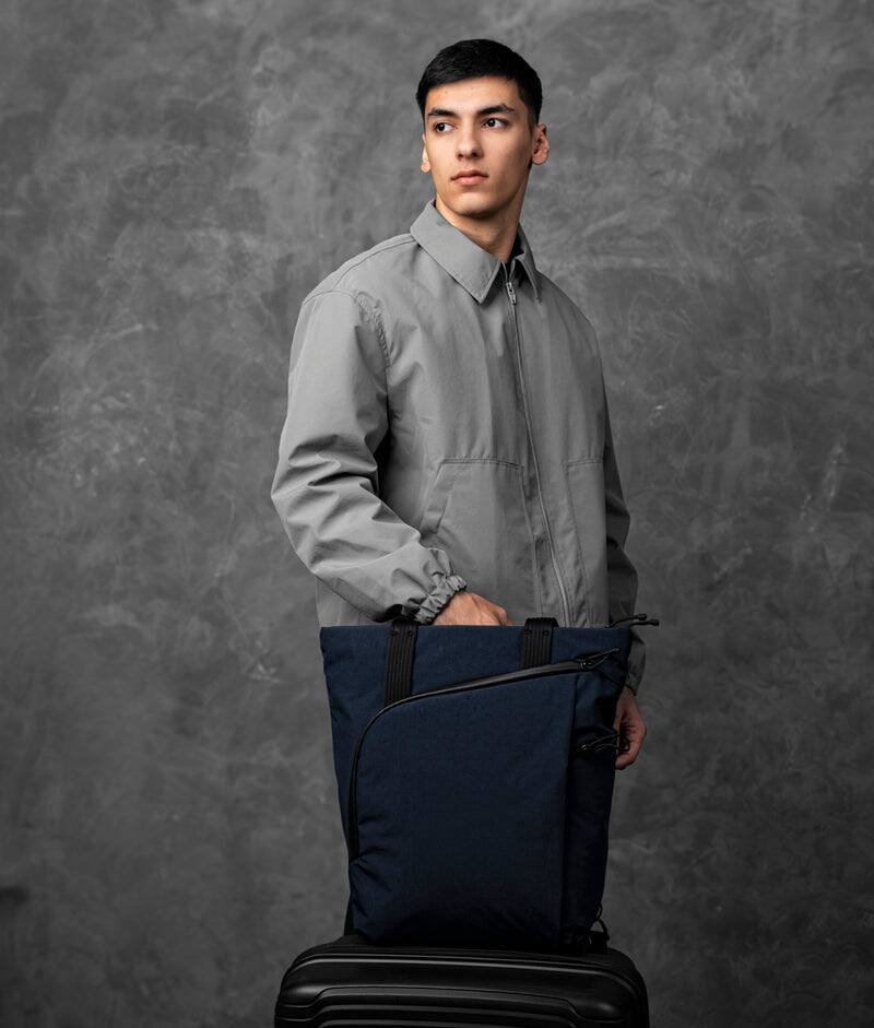 Angle. ALPAKA - Flow Totepack Laptop Backpack for Men, 16" Laptop Compartment + 11" Tablet Sleeve, Tote/Backpack, Bottle Pocket - Moonlight Blue Axoflux 400D Washed Nylon.