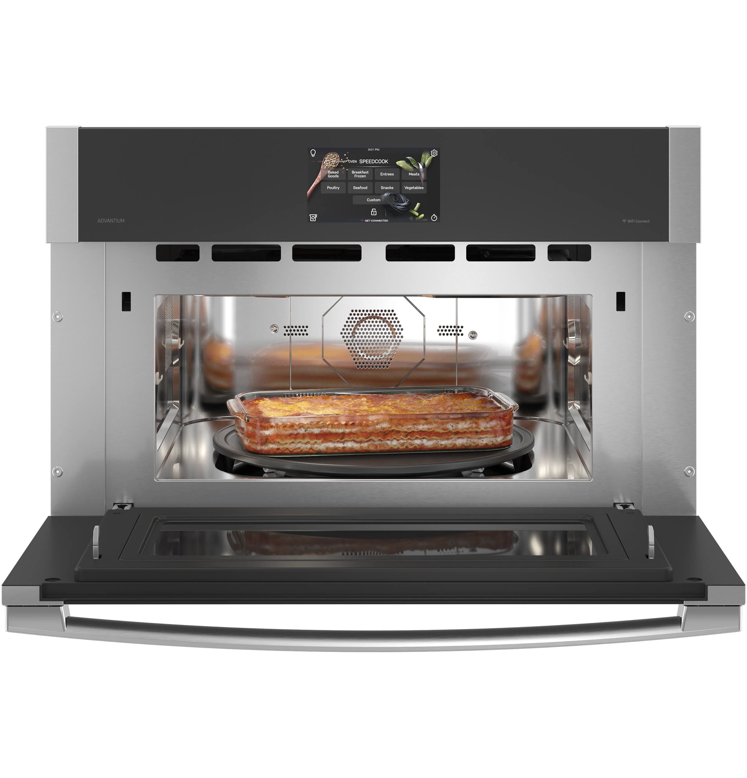 The image shows a stainless steel oven with a pizza inside. The oven has a digital display, and the pizza is cooking on a rack. The oven is likely a convection oven, as it is designed to evenly distribute heat for efficient cooking. The pizza is placed on a tray, and the oven is open, allowing us to see the cooking process.