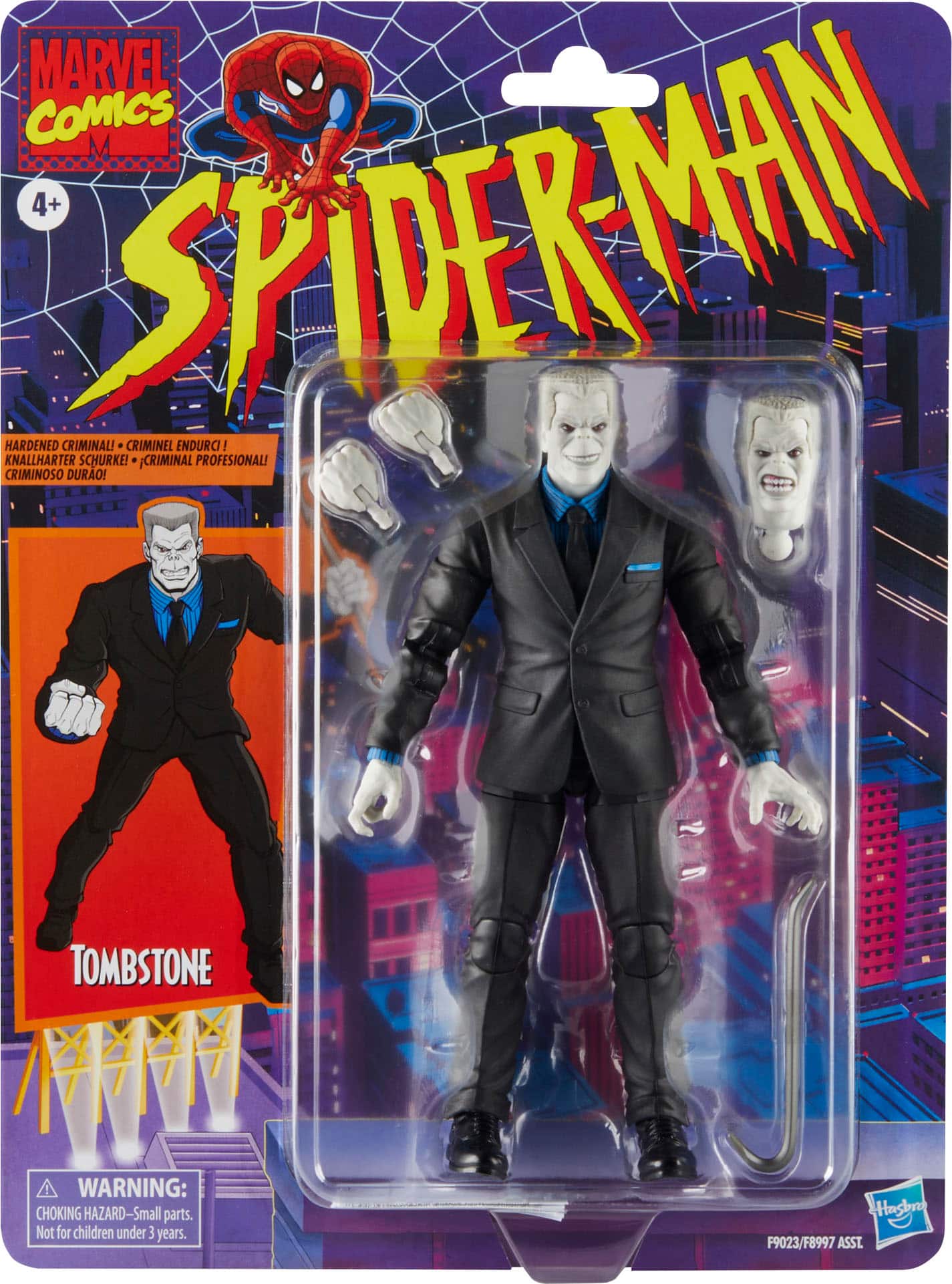 The text on the image is grouped as follows:
1. "MARVEL COMICS"
2. "4+ SPIDERMAN KNALLHARTER HARDENED CRIMINOSO CRIMINALI DURAO! SCHURKE! CRIMINEL CRIMINAL ENDURCI PROFESIONAL!"
3. "TOMBSTONE"
4. "WARNING: CHOKING HAZARD-Small parts. Not for children under 3 years. Hasbro F9023/F8997 ASST."