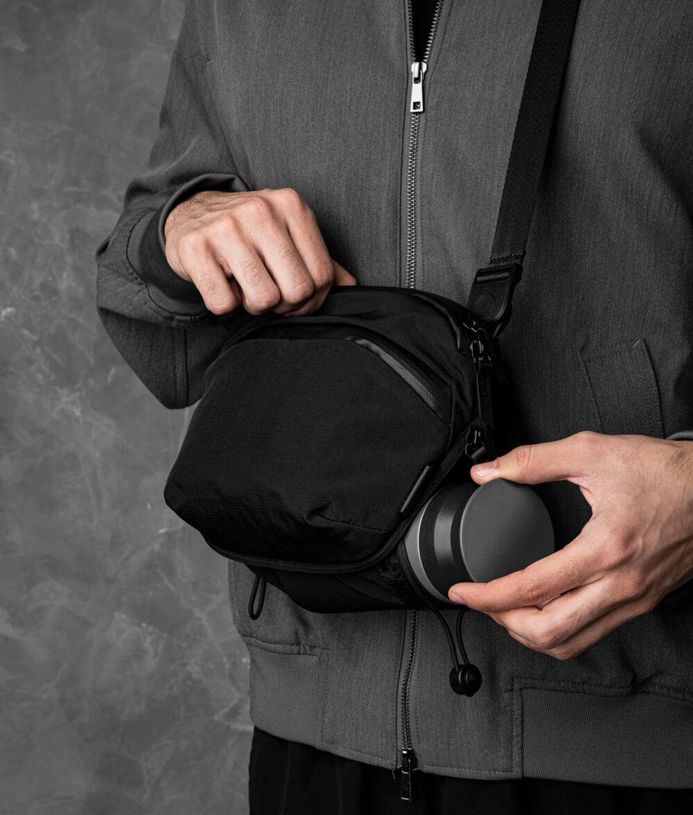 Left. ALPAKA - Flight Sling Pro 2.5L Sling Bag Crossbody Bag for Men, Bottle/Umbrella Sleeve, Fits 8.3" Tablet, YKK AquaGuard - Black Axoflux 400D Ripstop Nylon.