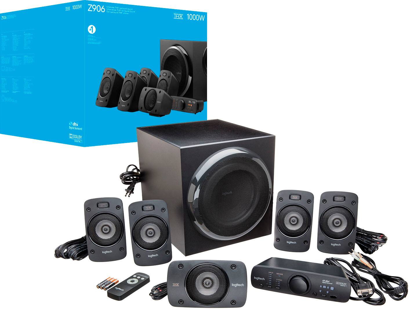 The image features a black speaker system with a total of 8 speakers, including a subwoofer. The speakers are arranged in various positions, with some placed on the ground and others on a table. The speaker system is accompanied by a remote control, which is located near the center of the image. The overall scene suggests a complete home audio setup, ready for use.