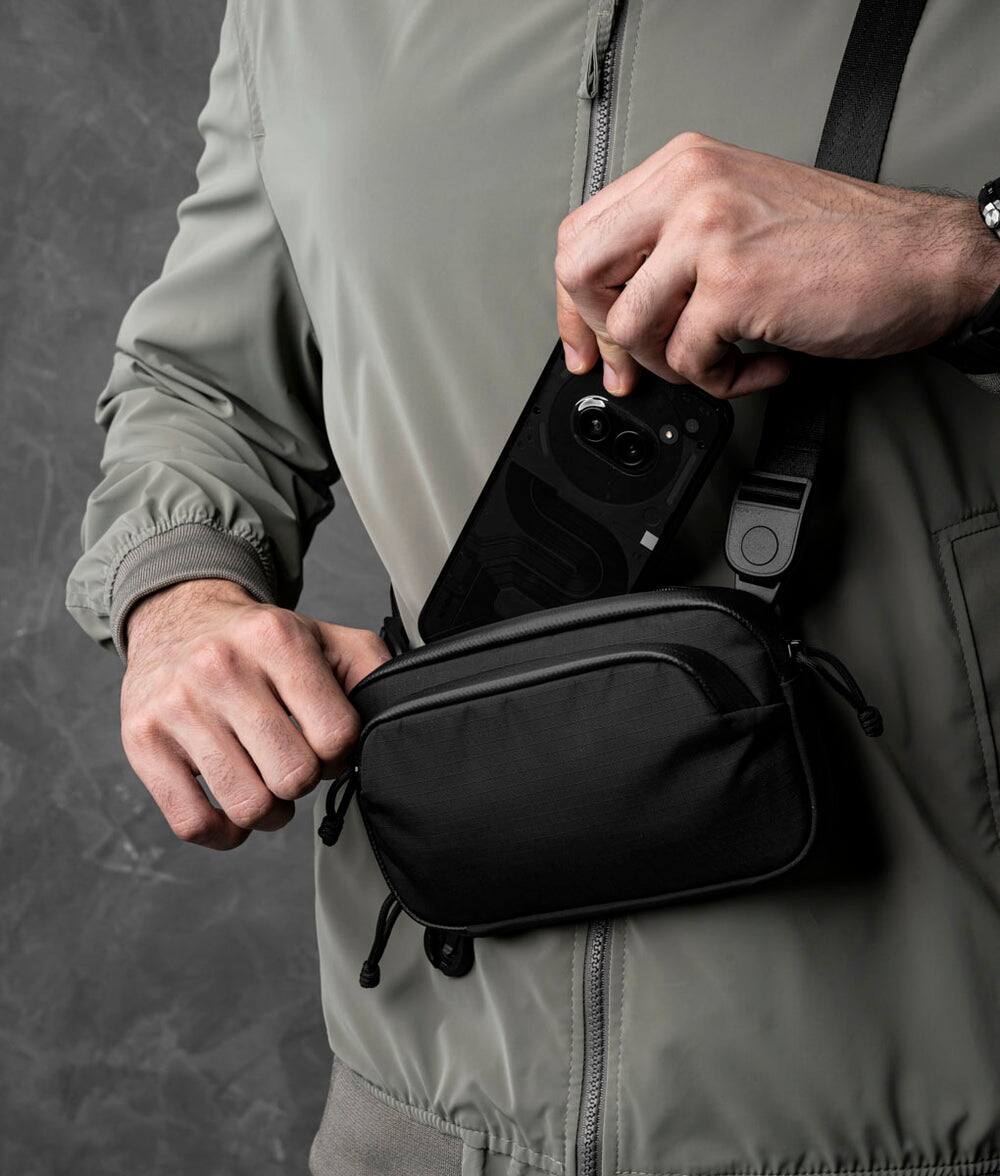 Alt View 1. ALPAKA - Bravo Passport Pouch Sling Bag for Men, Passport Holder for Travel, Fits iPhone Pro Max, RFID, AirTag Sleeve - Black Axoflux 210D.
