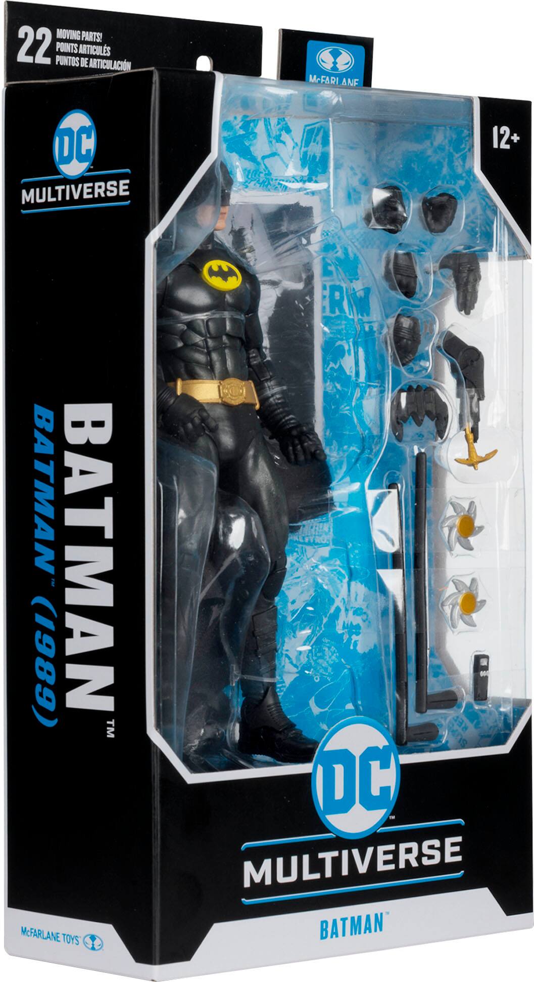 The image features a Batman figure from the DC Multiverse line. The figure is wearing a black suit and has a yellow belt. The packaging includes a display stand and a set of accessories, including a cape, a cowl, and a pair of sunglasses. The figure is designed to be posable, allowing collectors to create various action scenes. The packaging also includes a booklet with information about the figure and its accessories.