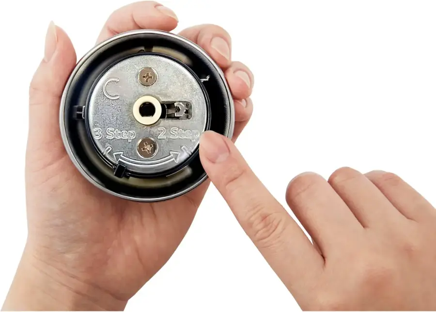 The text on the image reads "C H O 2 3 Step 2 Step a." However, it is unclear what the text is referring to or how it relates to the image of a person holding a small object. The text does not provide any context or information about the object or the person's actions.