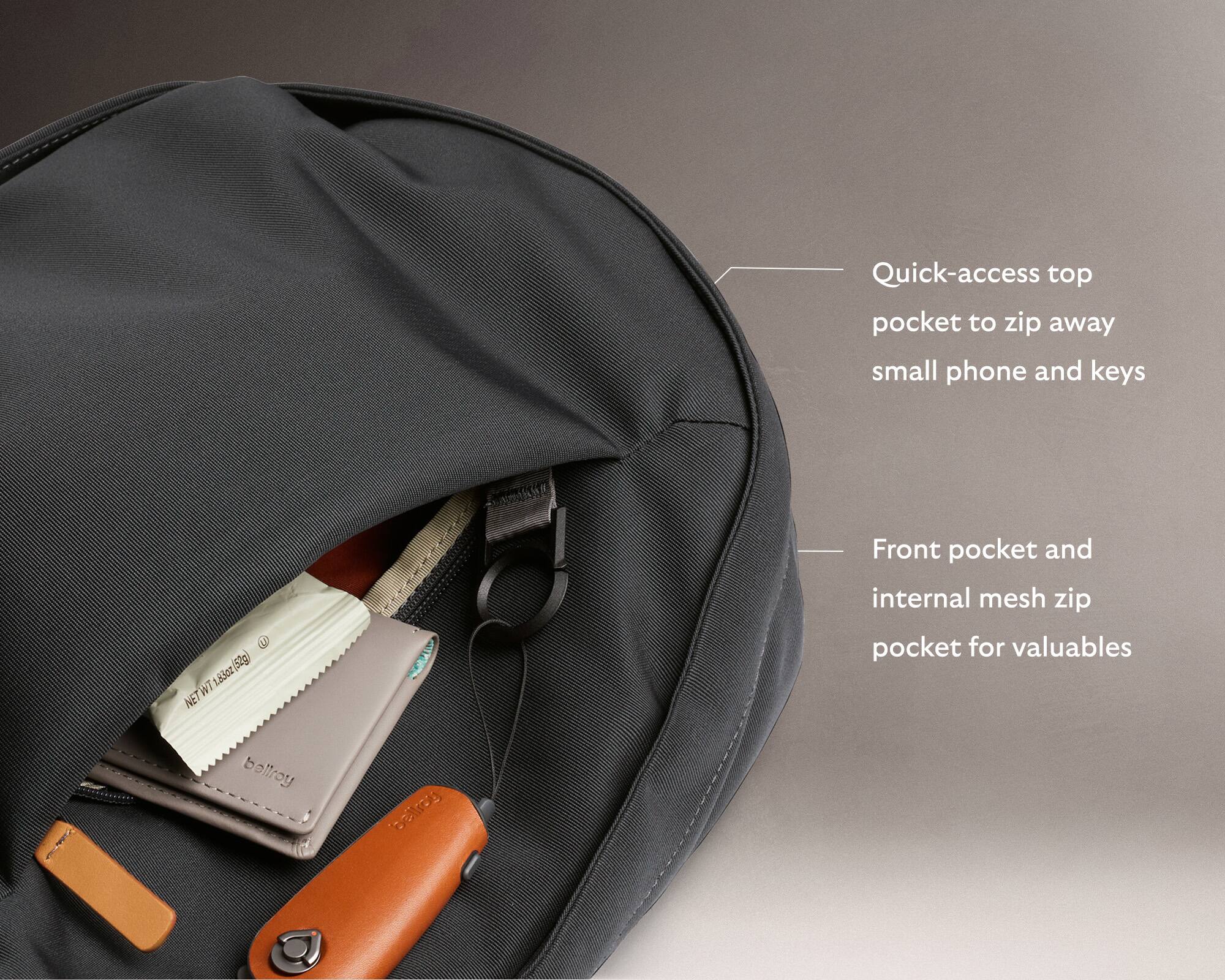 The image shows a backpack with a pocket that can be accessed quickly, allowing for easy access to small items like a phone and keys. The pocket is designed to zip away, keeping the items secure and organized. The backpack also features a front pocket and an internal mesh zip pocket for valuables. The brand of the backpack is Bellroy.
