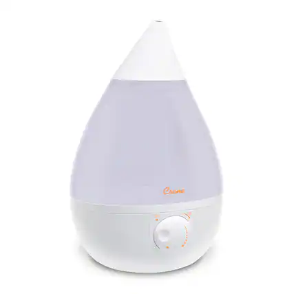 The image features a white Crane humidifier, which is currently turned off. The humidifier has a white base and a clear glass container. The device is designed to release moisture into the air, providing a comfortable and humid environment.