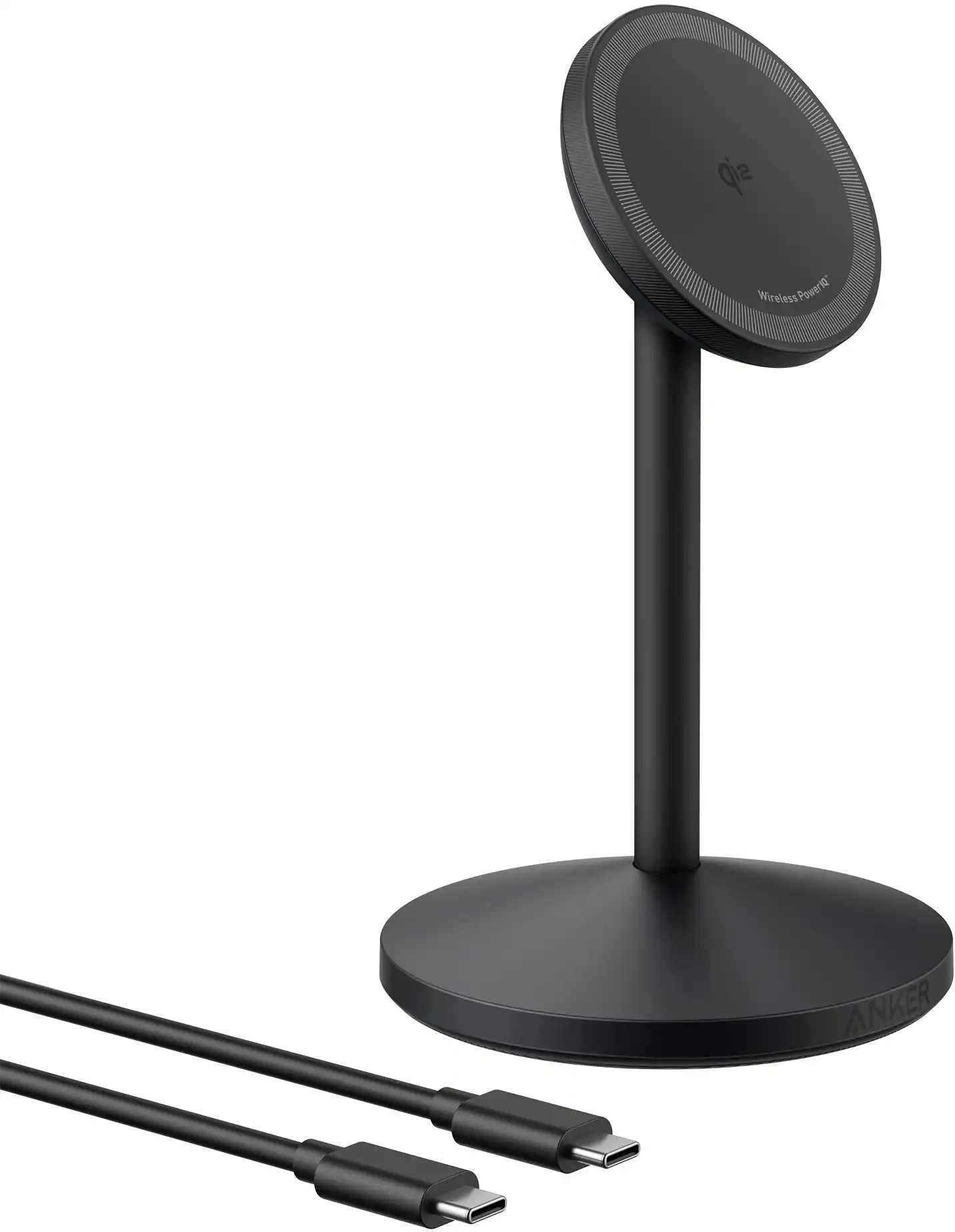 The image features a black Anker Wireless Power 10 stand with a circular base. The stand is holding a round speaker, which is connected to a computer. The speaker is placed on a table, and there are two cords visible in the image. The cords are likely used for charging or connecting the speaker to the computer.