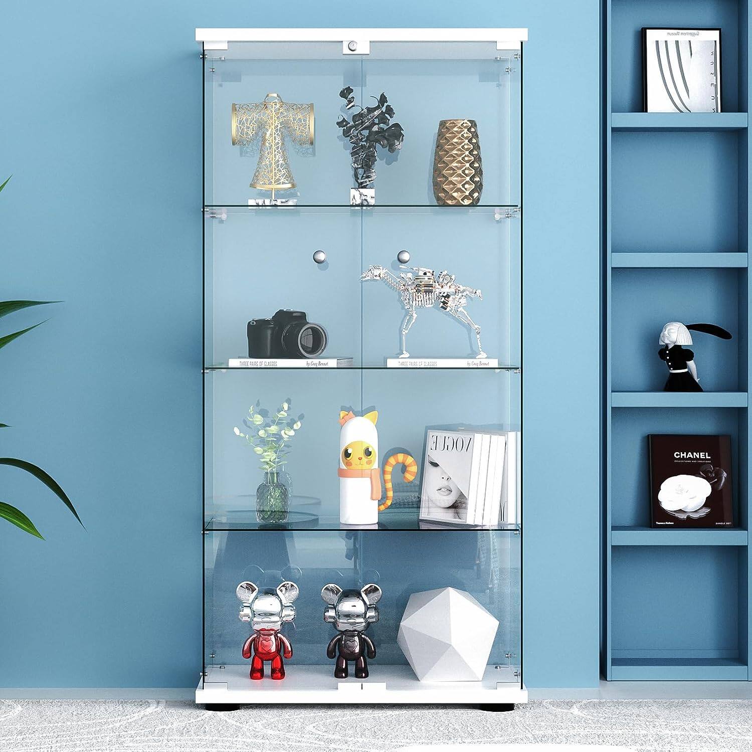 Sure, here is the corrected and grouped text from the image:

---

**Top Shelf:**
- MES
- Le bngln
- SE LERA2 E
- E. VOGU CHANEL

**Middle Shelf:**
- CHANEL
- 1920-2020
- 100 ans de luxe

**Bottom Shelf:**
- CHANEL
- 1920-2020
- 100 ans de luxe

**Right Shelf:**
- CHANEL
- 1920-2020
- 100 ans de luxe

---

This text appears to be part of the display items and labels within the glass cabinet.